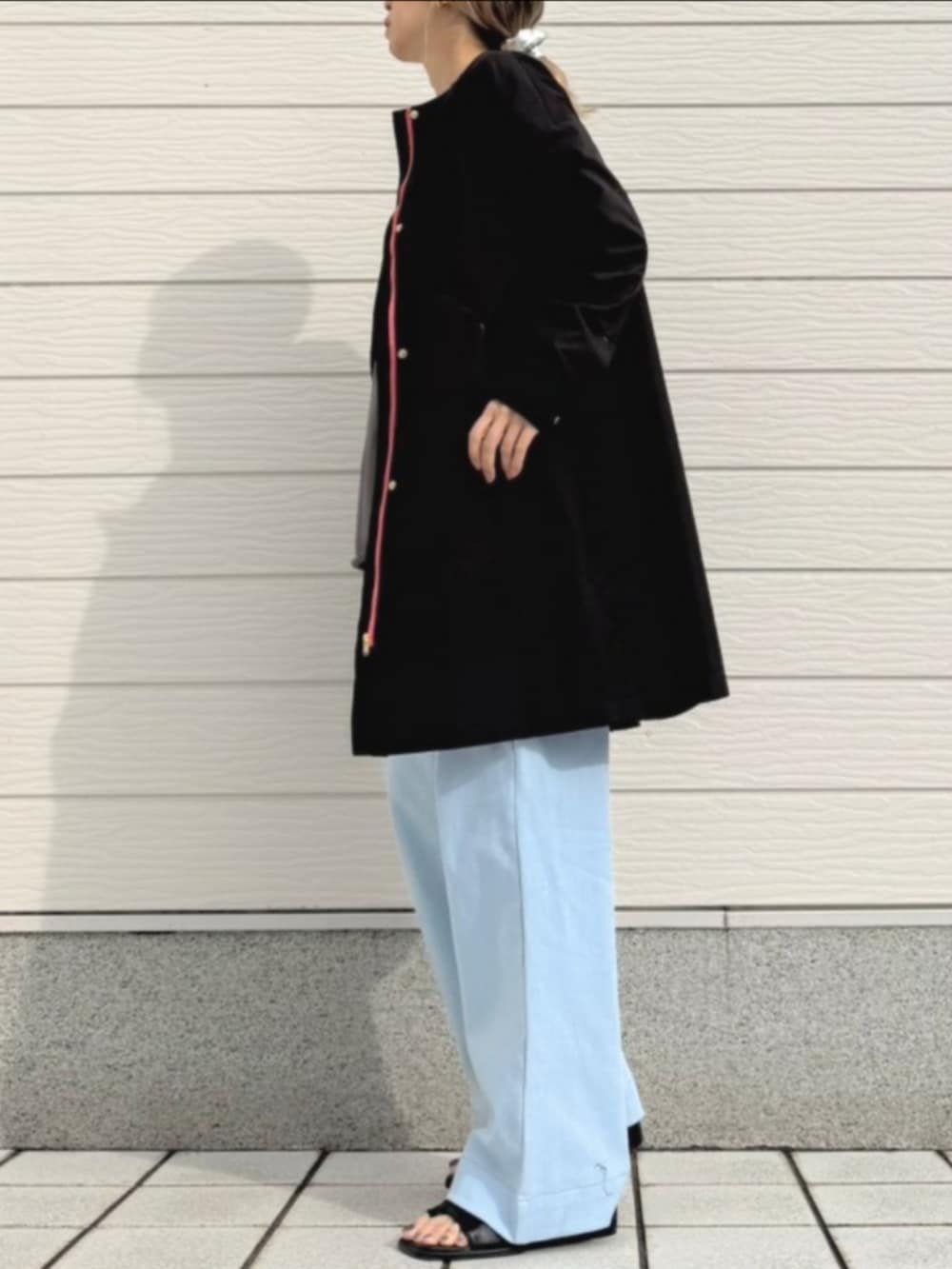 ブルー系のデニムパンツ、ブラック系のサンダル、グレー系のスウェットを着用したレディースの冬コーディネートの2枚目の写真