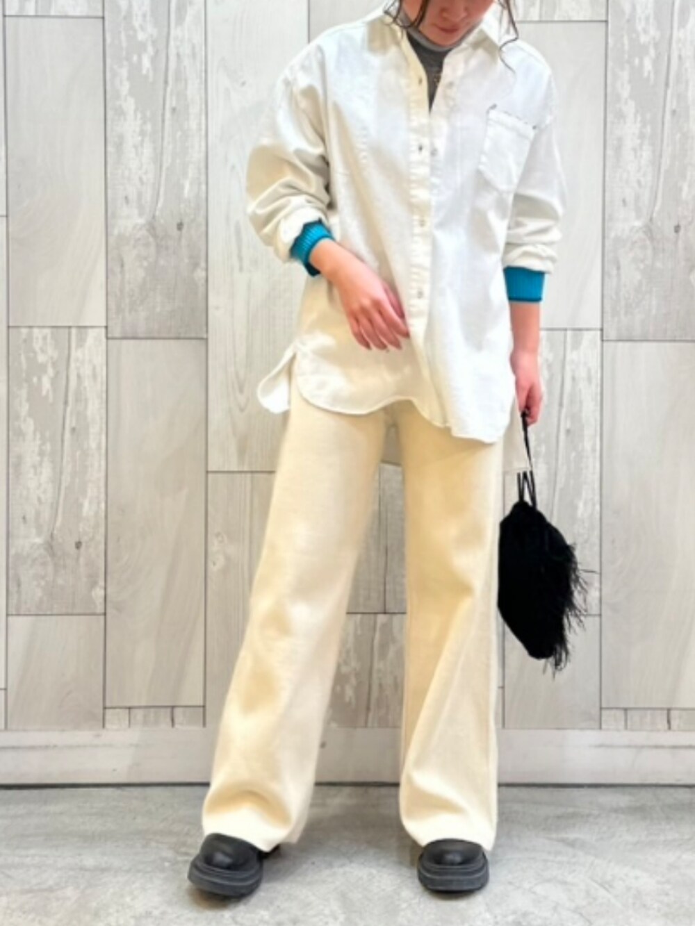 ホワイト系のその他パンツ、ブラック系のクラッチバッグ、ホワイト系のシャツ/ブラウスを着用したレディースの冬コーディネートの2枚目の写真