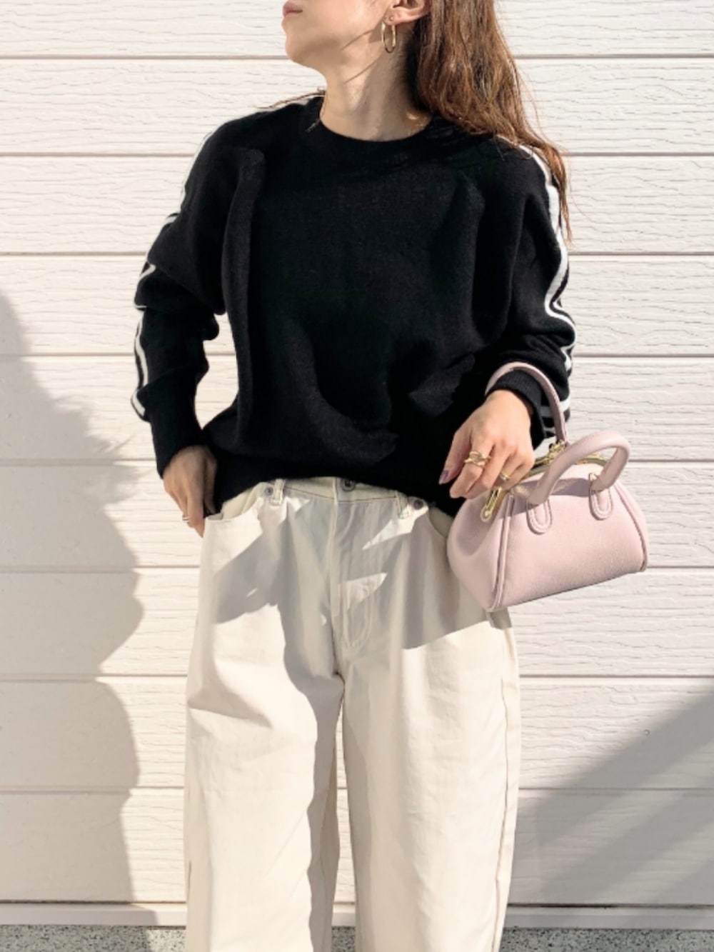 ホワイト系のデニムパンツ、ブラック系のローファー、ピンク系のショルダーバッグを着用したレディースの冬コーディネートの3枚目の写真