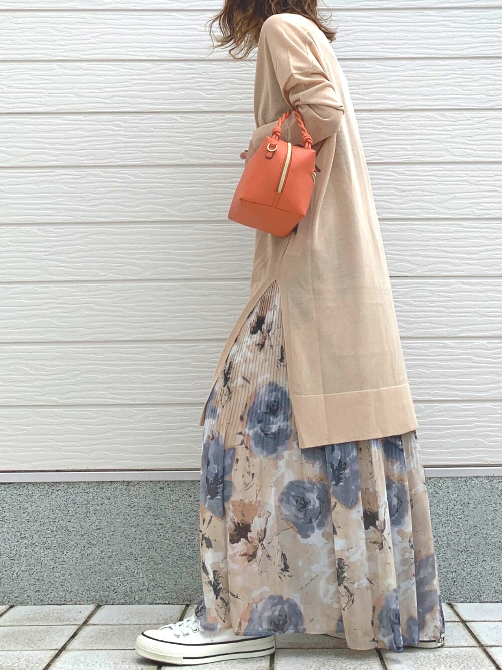 オレンジ系のハンドバッグ、イエロー系のスカート、ホワイト系のスニーカーを着用したレディースの春コーディネートの2枚目の写真