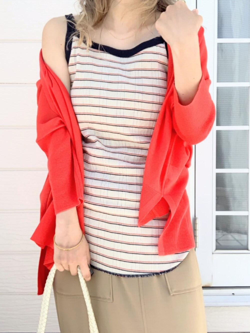 イエロー系のサンダル、オレンジ系のカーディガン/ボレロ、ホワイト系のトートバッグを着用したレディースの春コーディネートの5枚目の写真