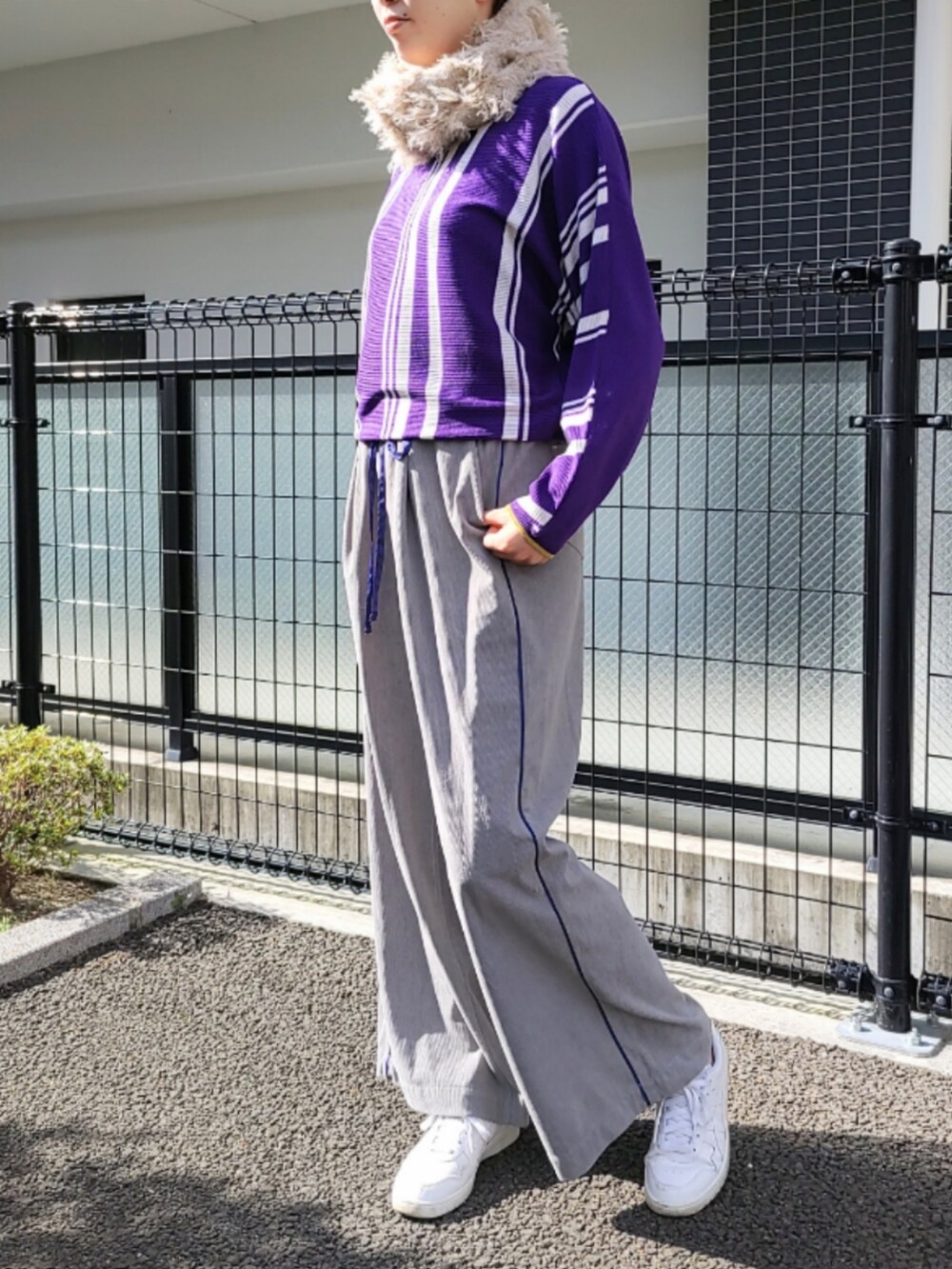 パープル系のニット/セーター、ホワイト系のスニーカー、グレー系のその他パンツを着用したレディースの秋コーディネートの2枚目の写真