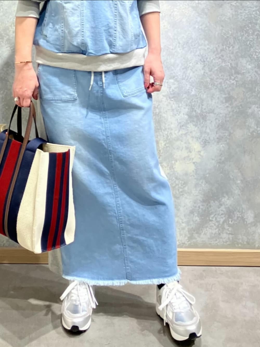 ブルー系のスカート、ブルー系のスウェット、シルバー系のスニーカーを着用したレディースの冬コーディネートの5枚目の写真