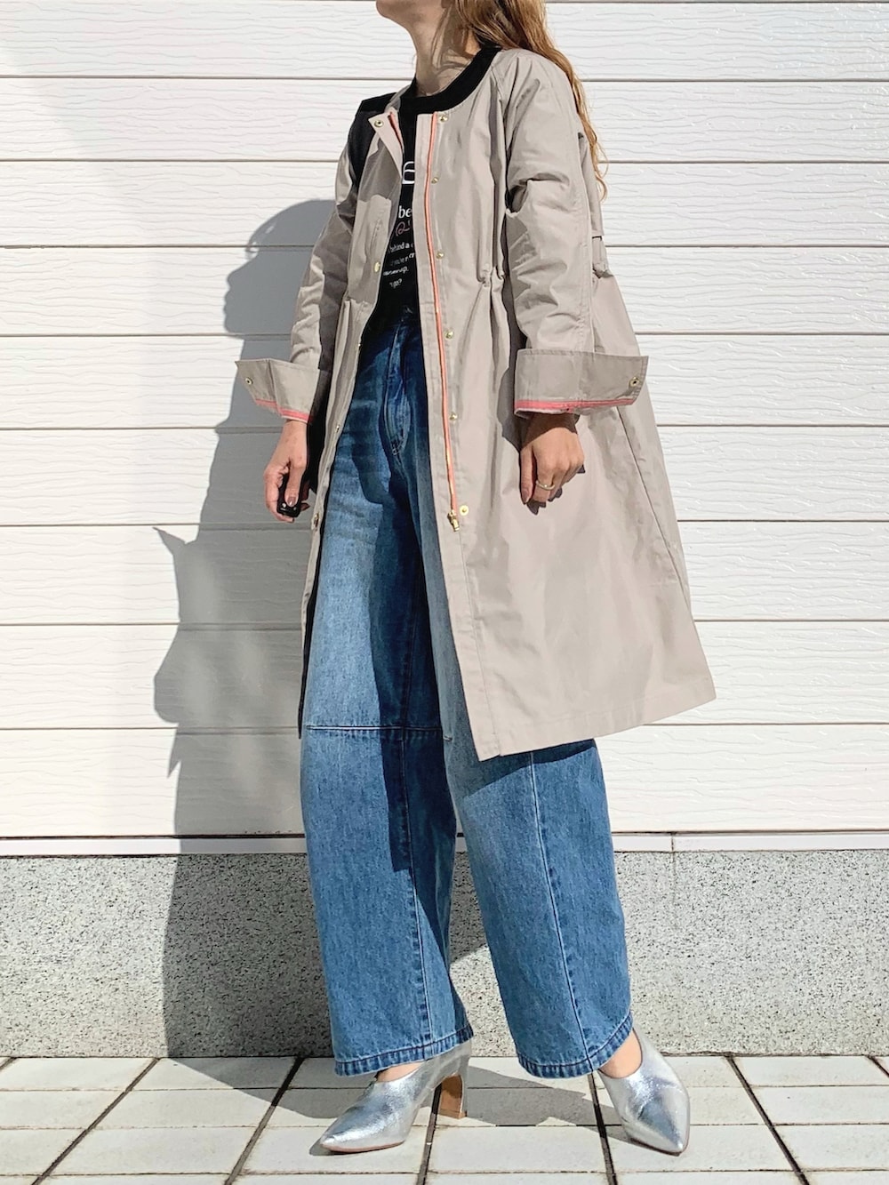 ブルー系のデニムパンツ、ブラック系のショルダーバッグ、ベージュ系のノーカラーコートを着用したレディースの春コーディネートの2枚目の写真