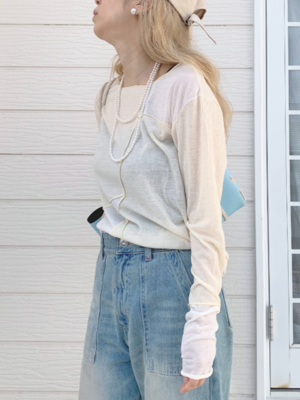 ブルー系のデニムパンツ、ブルー系のトートバッグ、ベージュ系のTシャツ/カットソーを着用したレディースの春コーディネートの4枚目の写真