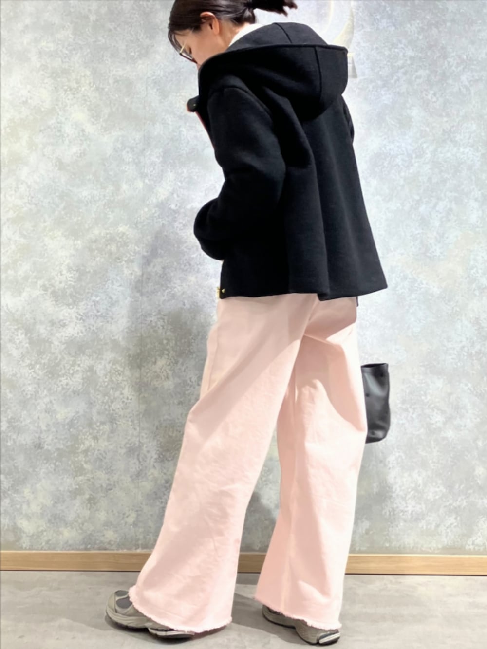 ブラック系のトートバッグ、ピンク系のデニムパンツ、ホワイト系のニット/セーターを着用したレディースの冬コーディネートの4枚目の写真