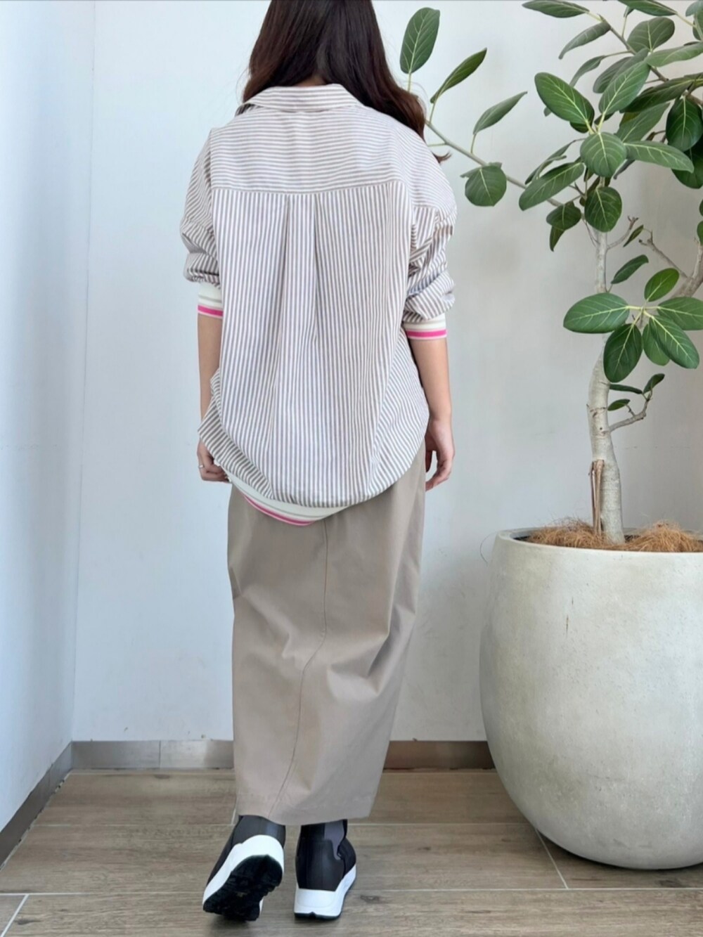 ベージュ系のシャツ/ブラウス、グレー系のスカート、グレー系のブーツを着用したレディースの秋コーディネートの2枚目の写真