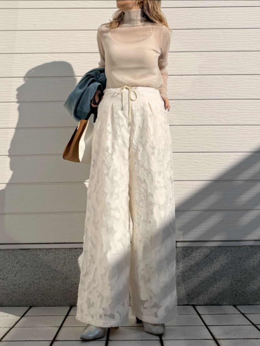 ブルー系のデニムジャケット、ホワイト系のトートバッグ、ホワイト系のTシャツ/カットソーを着用したレディースの冬コーディネートの4枚目の写真