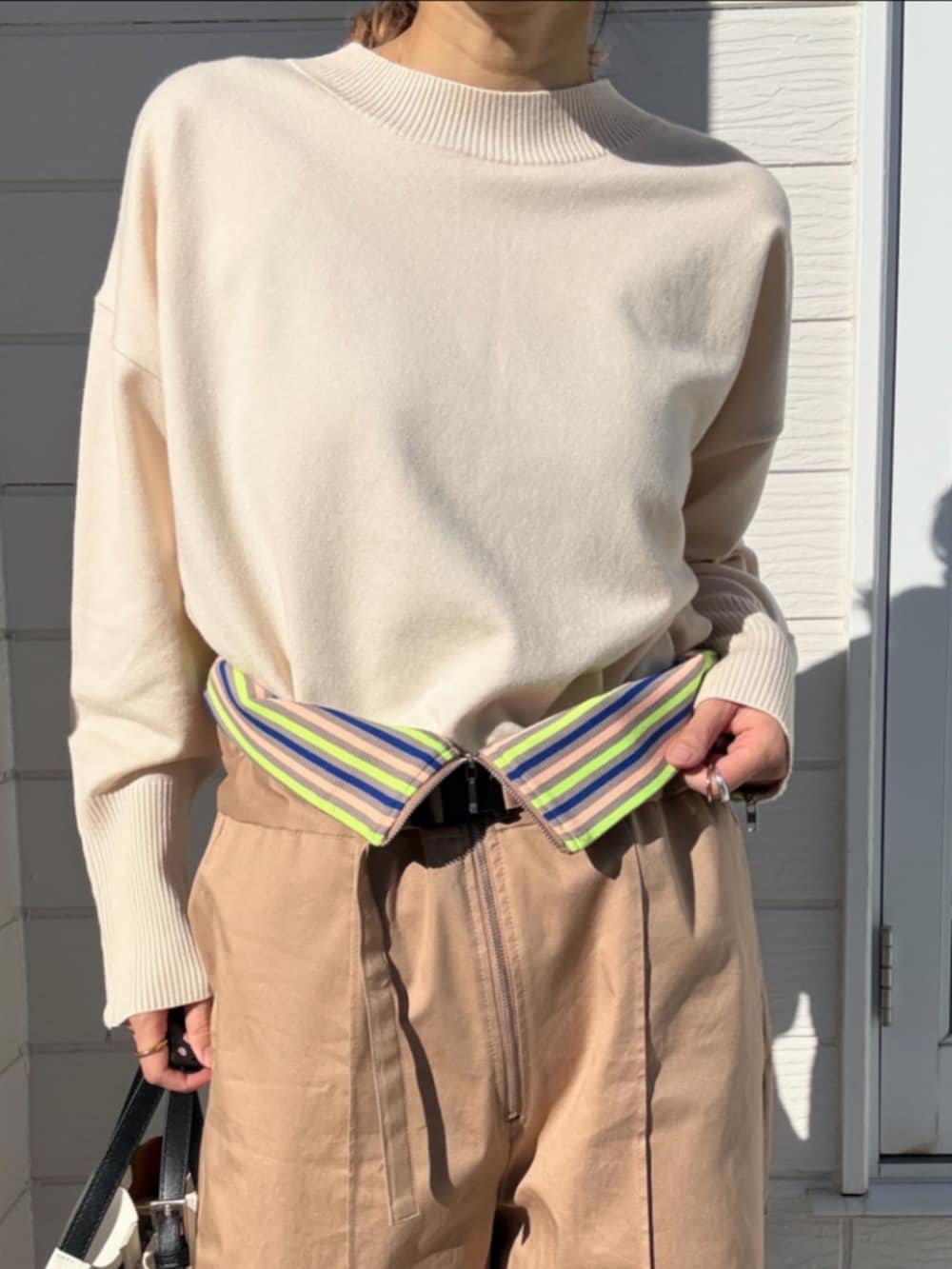 ホワイト系のスニーカー、ホワイト系のニット/セーター、ベージュ系のその他パンツを着用したレディースの冬コーディネートの4枚目の写真