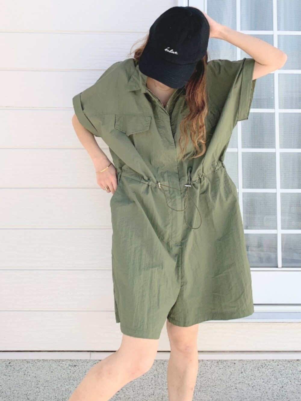 ホワイト系のスニーカー、グリーン系のつなぎ/オールインワン、ブラック系のキャップを着用したレディースの春コーディネートの3枚目の写真