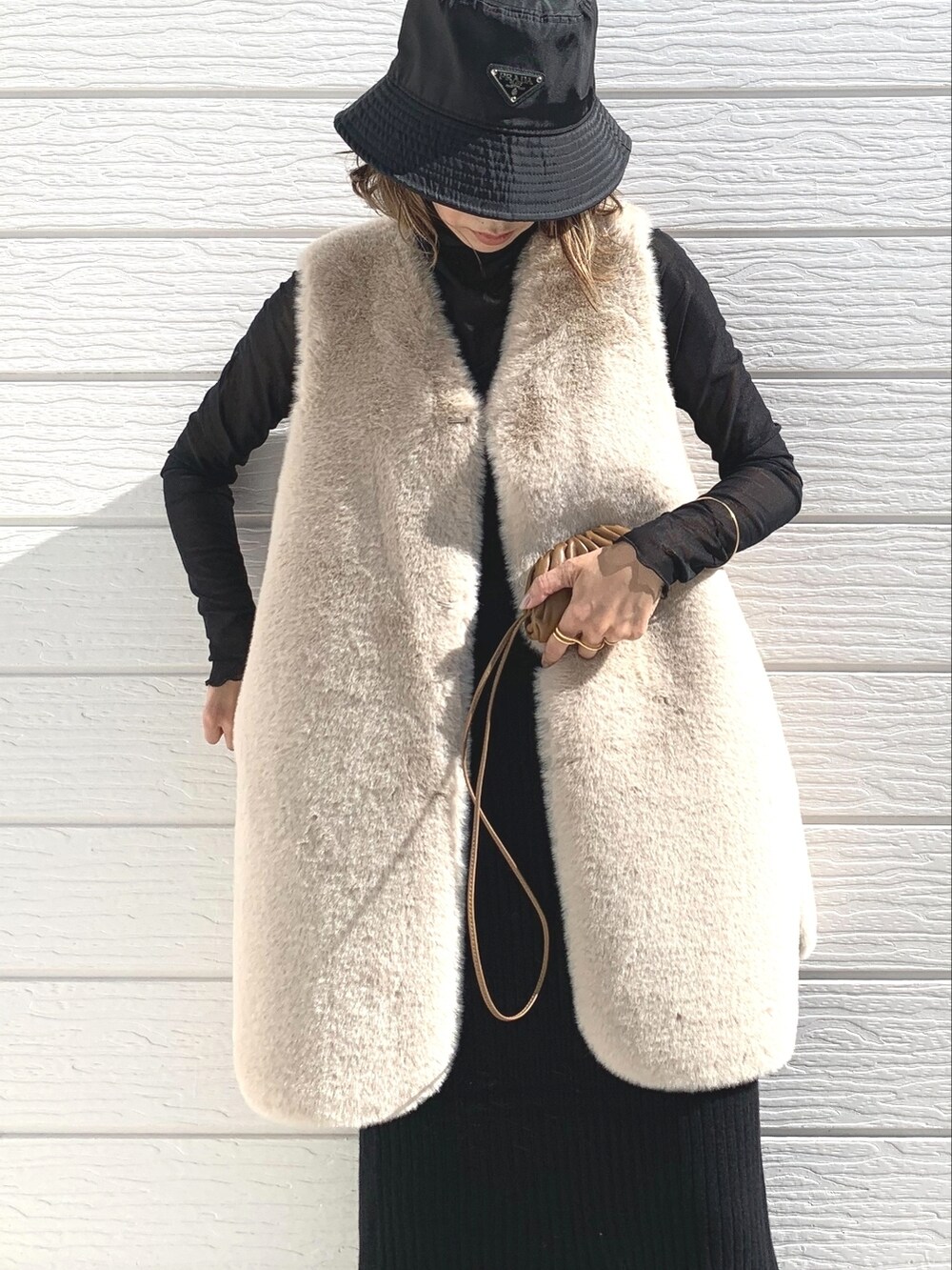 ブラウン系のバッグ、ブラック系のTシャツ/カットソー、ブラック系のスカートを着用したレディースの秋コーディネートの3枚目の写真