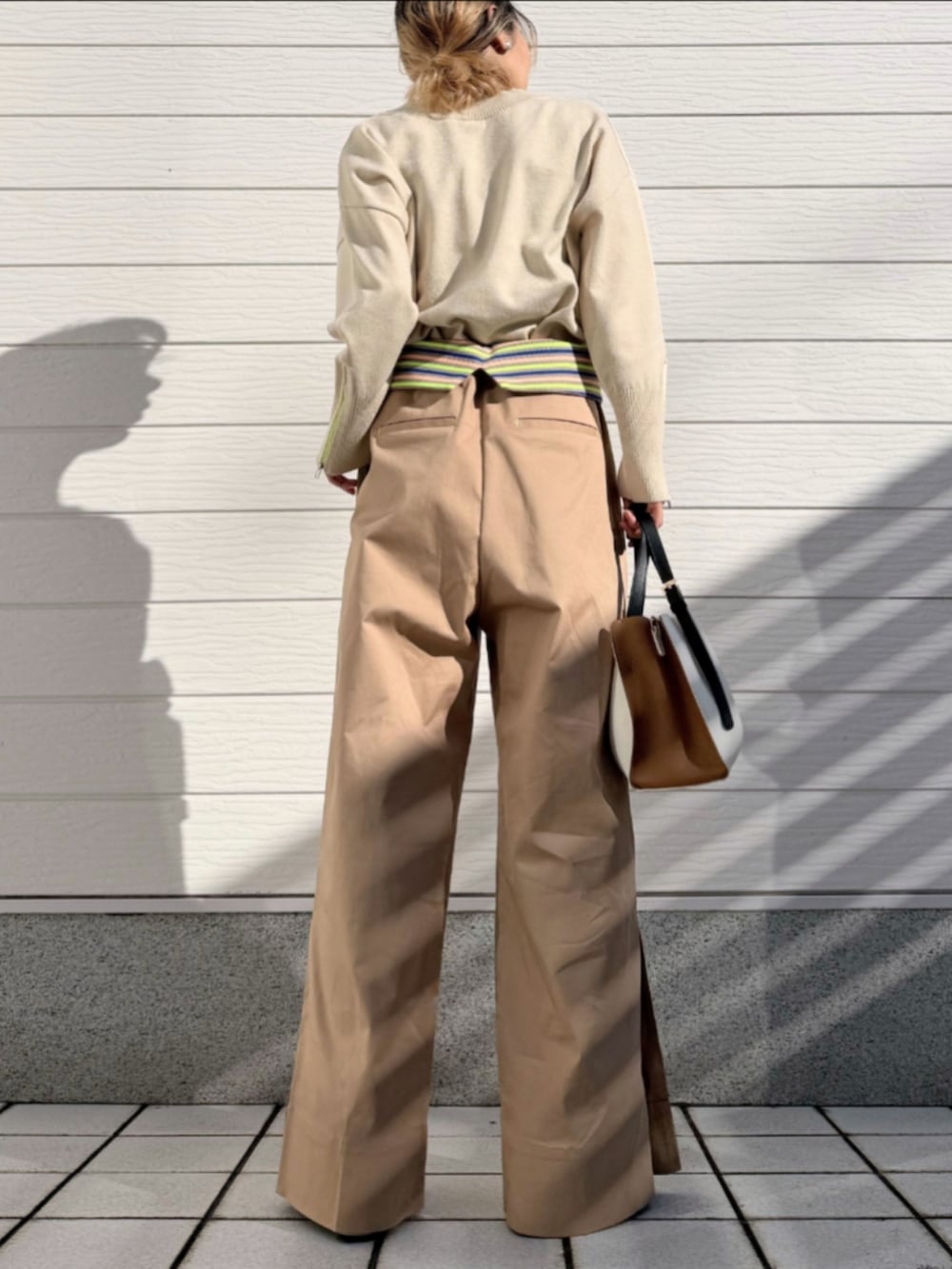 ホワイト系のスニーカー、ホワイト系のニット/セーター、ベージュ系のその他パンツを着用したレディースの冬コーディネートの3枚目の写真