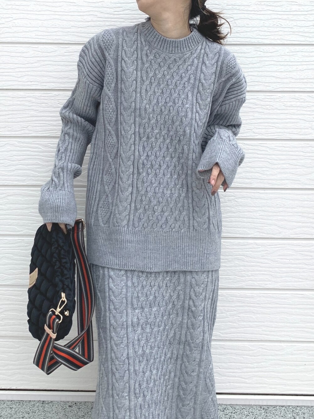 ブラック系のショルダーバッグ、グレー系のスカート、グレー系のニット/セーターを着用したレディースの冬コーディネートの4枚目の写真