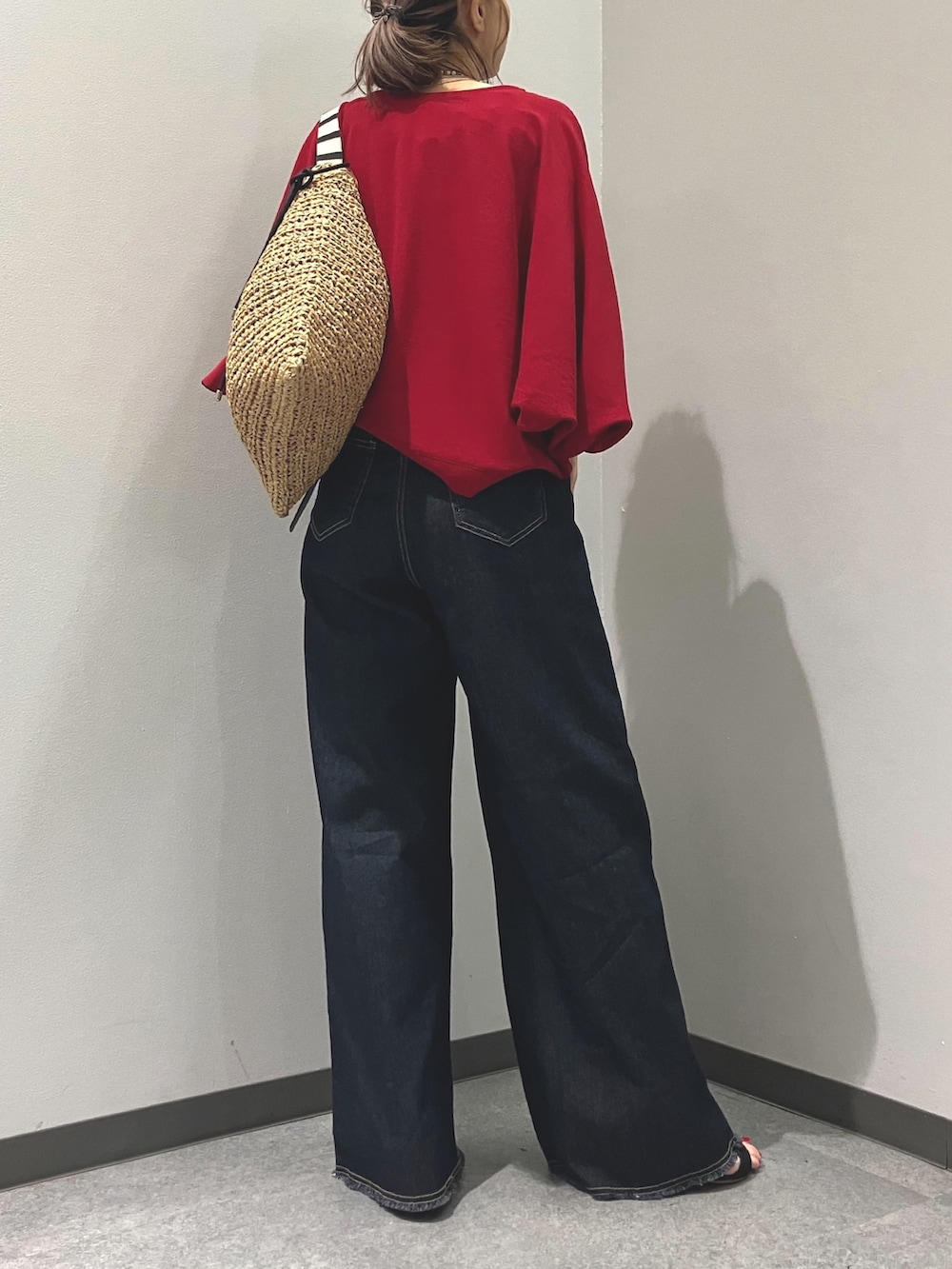 ブルー系のデニムパンツ、レッド系のシャツ/ブラウス、グリーン系のトートバッグを着用したレディースの夏コーディネートの3枚目の写真