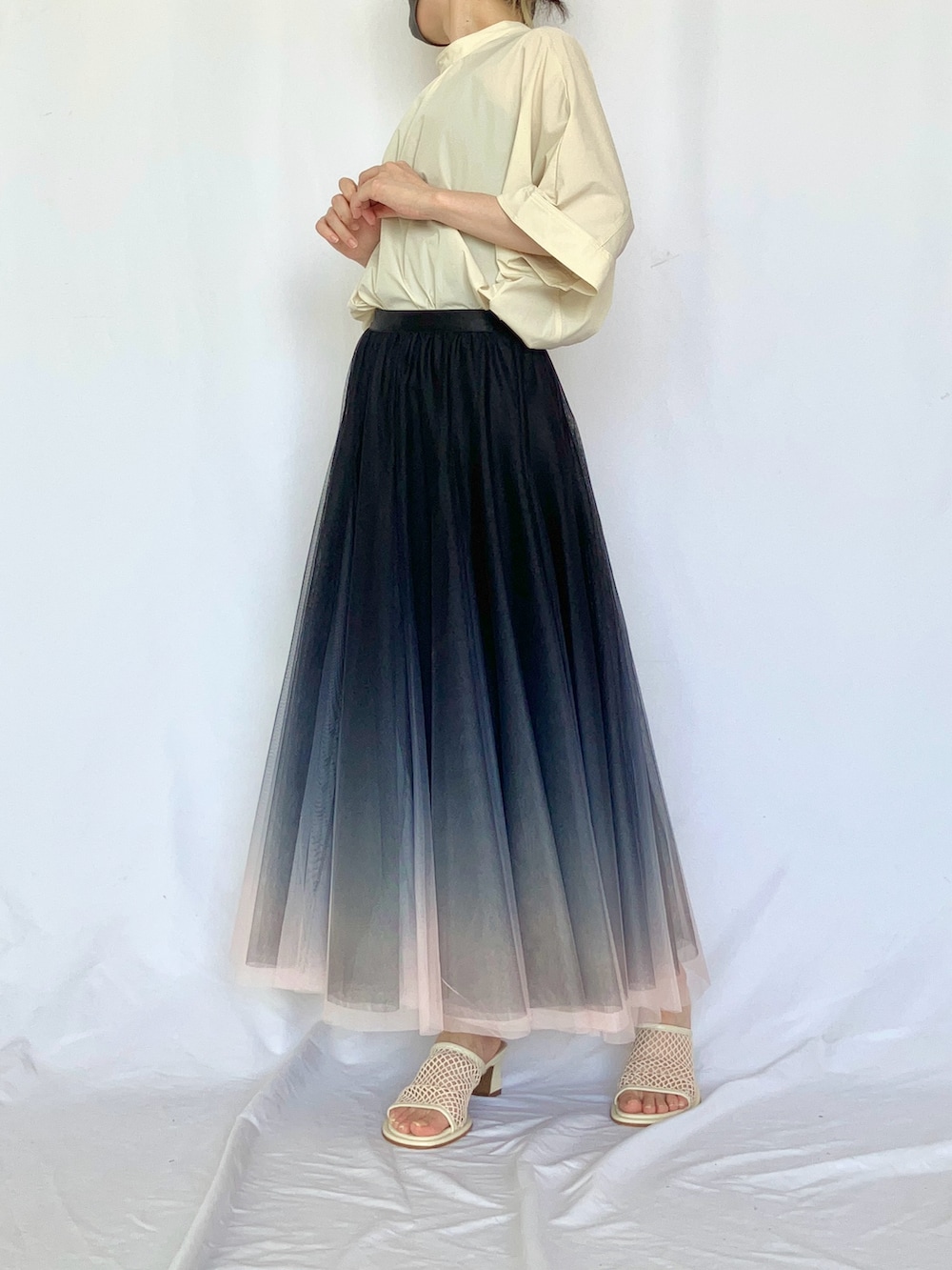 ホワイト系のシャツ/ブラウス、グレー系のサンダル、ブラック系のスカートを着用したレディースの夏コーディネートの2枚目の写真
