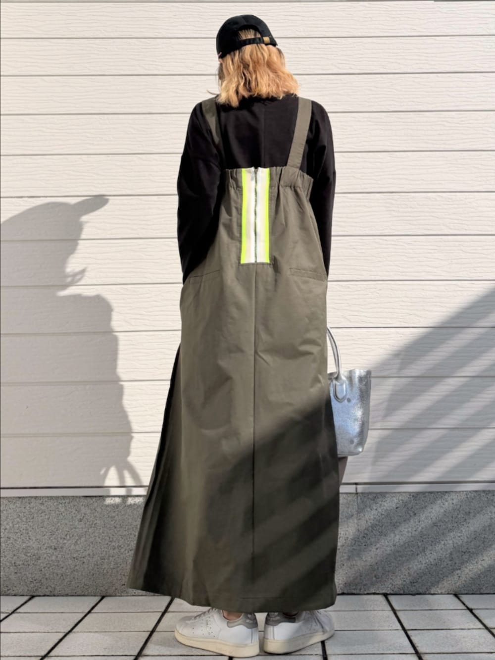 グリーン系のワンピース、ホワイト系のスニーカー、シルバー系のトートバッグを着用したレディースの冬コーディネートの3枚目の写真