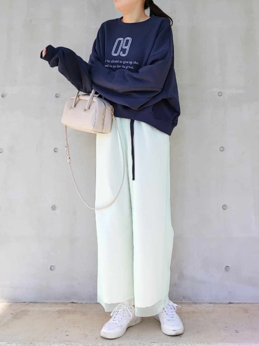 ベージュ系のその他パンツ、ホワイト系のスニーカー、ホワイト系のボストンバッグを着用したレディースの冬コーディネートの3枚目の写真