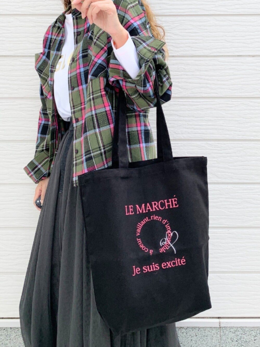 ブラック系のスカート、ホワイト系のスニーカー、ホワイト系のTシャツ/カットソーを着用したレディースの秋コーディネートの5枚目の写真