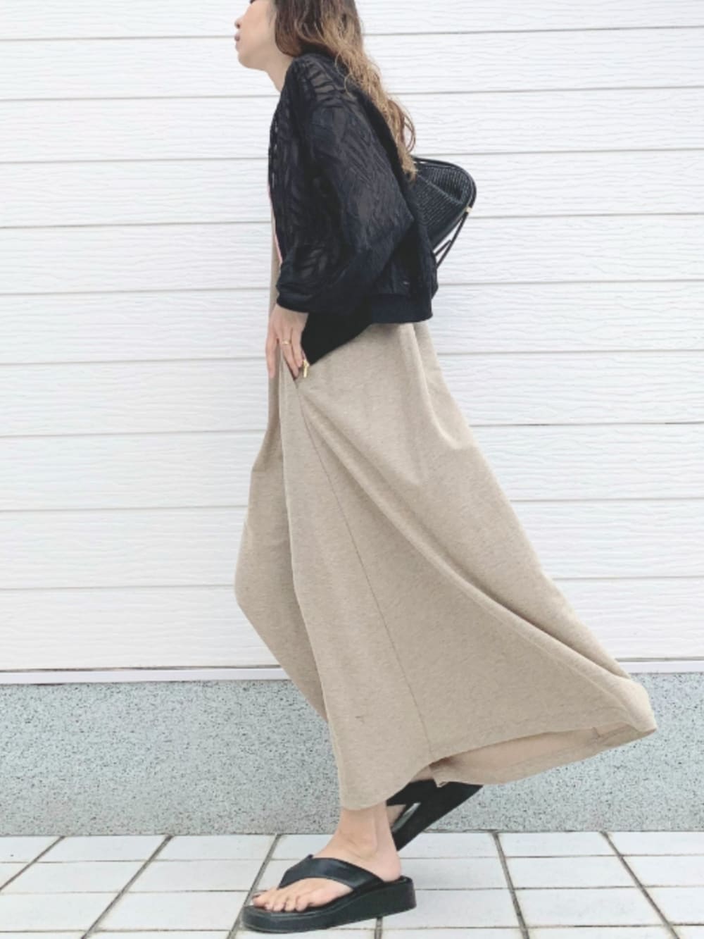 ブラック系のショルダーバッグ、ベージュ系のワンピース、ブラック系のブルゾンを着用したレディースの春コーディネートの2枚目の写真