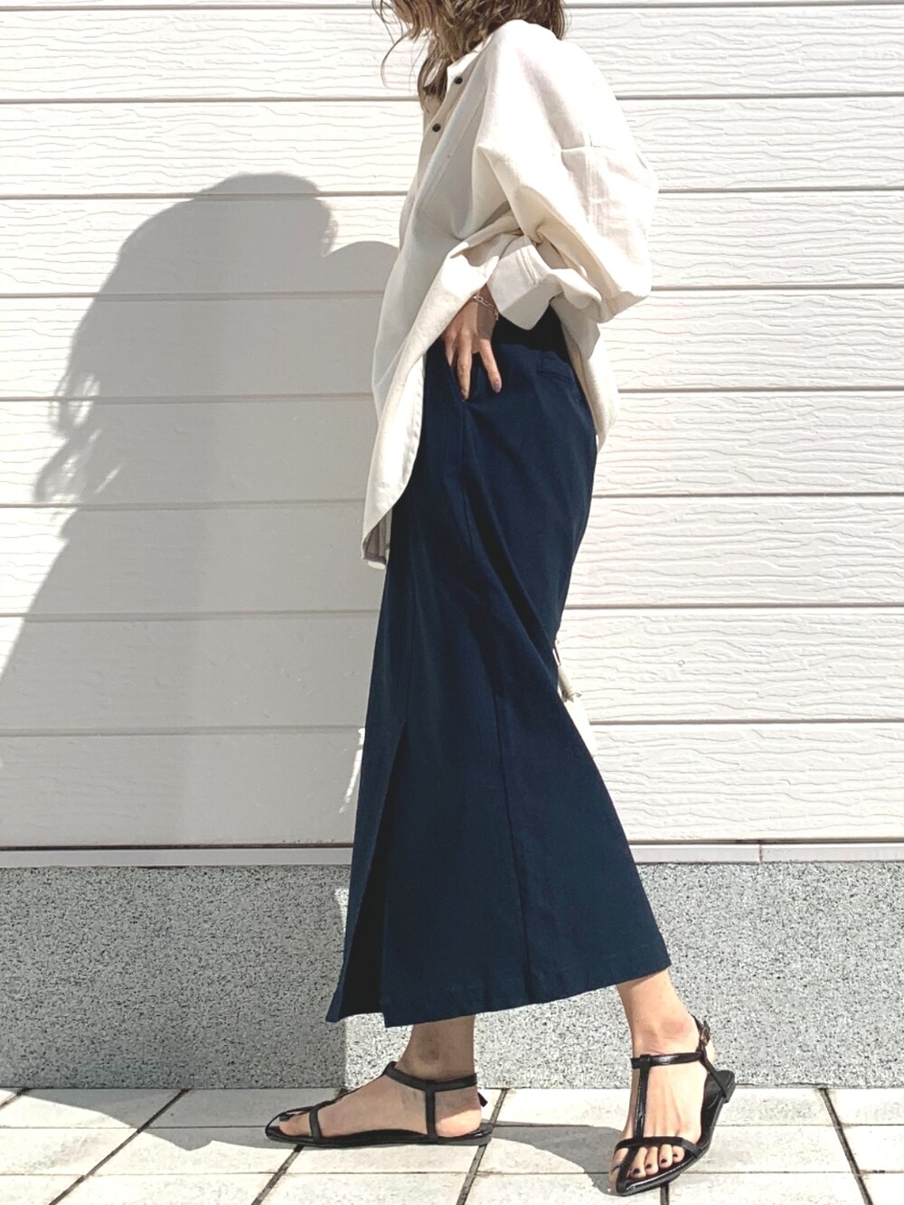 ホワイト系のショルダーバッグ、ブルー系のスカート、ホワイト系のシャツ/ブラウスを着用したレディースの冬コーディネートの2枚目の写真