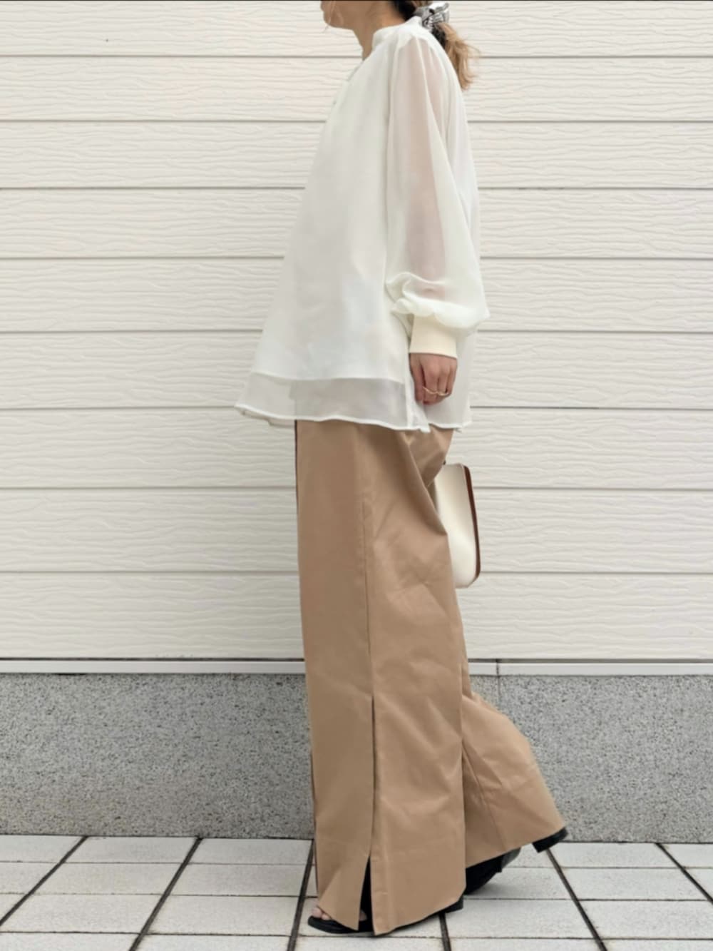 ベージュ系のその他パンツ、ホワイト系のシャツ/ブラウス、ホワイト系のトートバッグを着用したレディースの冬コーディネートの2枚目の写真
