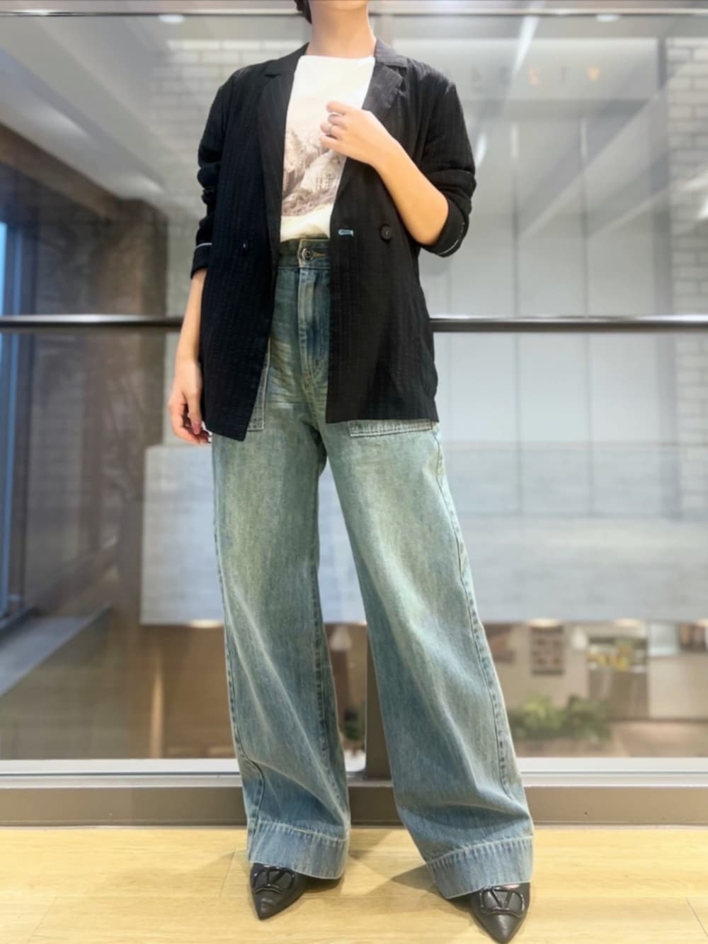 ブルー系のデニムパンツ、ホワイト系のTシャツ/カットソーを着用したレディースの秋コーディネートの3枚目の写真