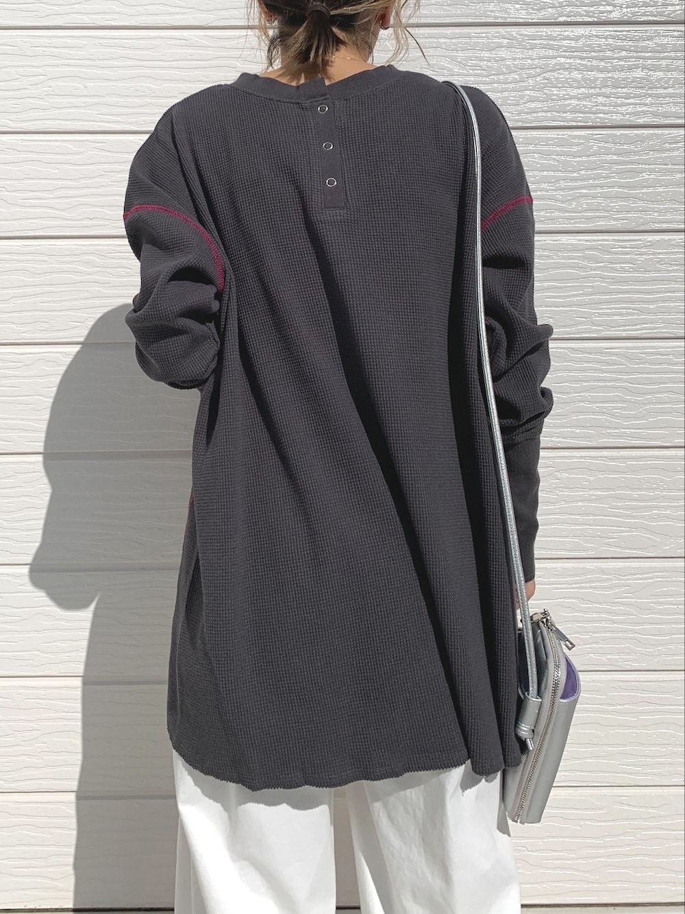 ホワイト系のデニムパンツ、シルバー系のショルダーバッグ、シルバー系のスニーカーを着用したレディースの秋コーディネートの3枚目の写真