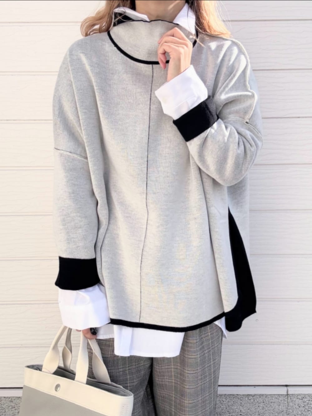 グレー系のトートバッグ、ホワイト系のシャツ/ブラウス、ブラック系のニット/セーターを着用したレディースの冬コーディネートの4枚目の写真