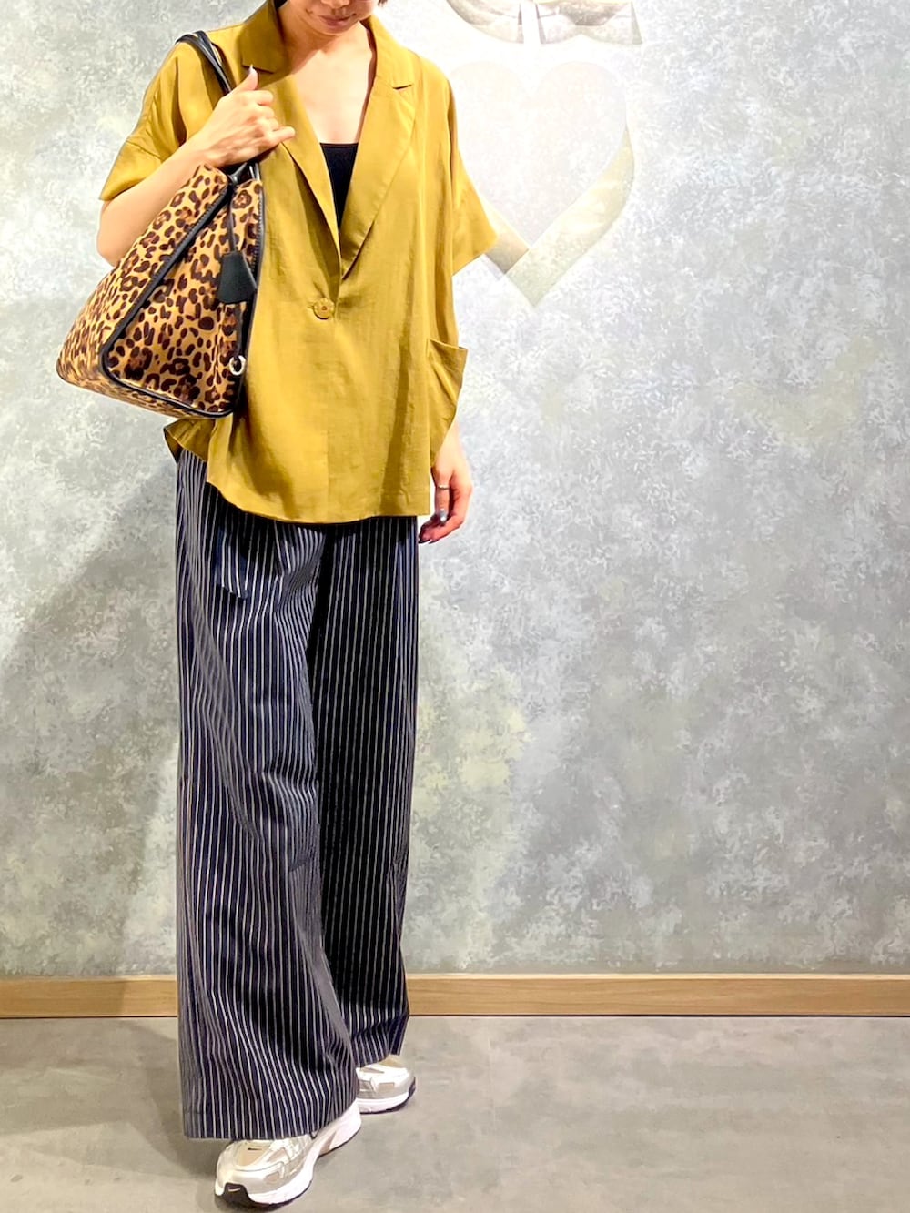 ブルー系のその他パンツ、ブラウン系のトートバッグ、グリーン系のテーラードジャケットを着用したレディースの夏コーディネートの3枚目の写真