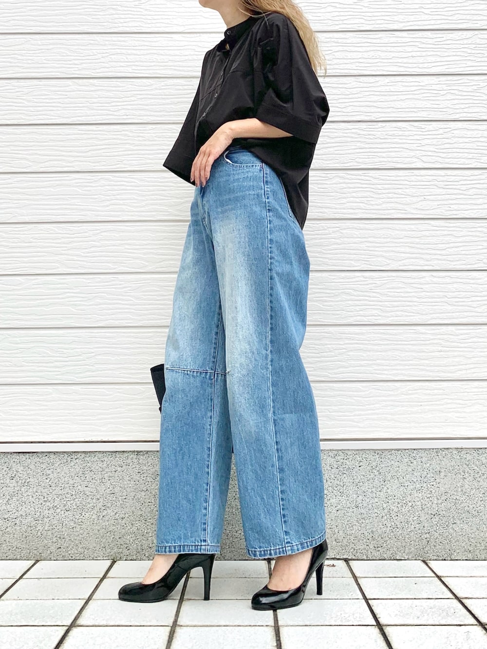 ブラック系のシャツ/ブラウス、ブルー系のデニムパンツ、ブルー系のトートバッグを着用したレディースの夏コーディネートの2枚目の写真
