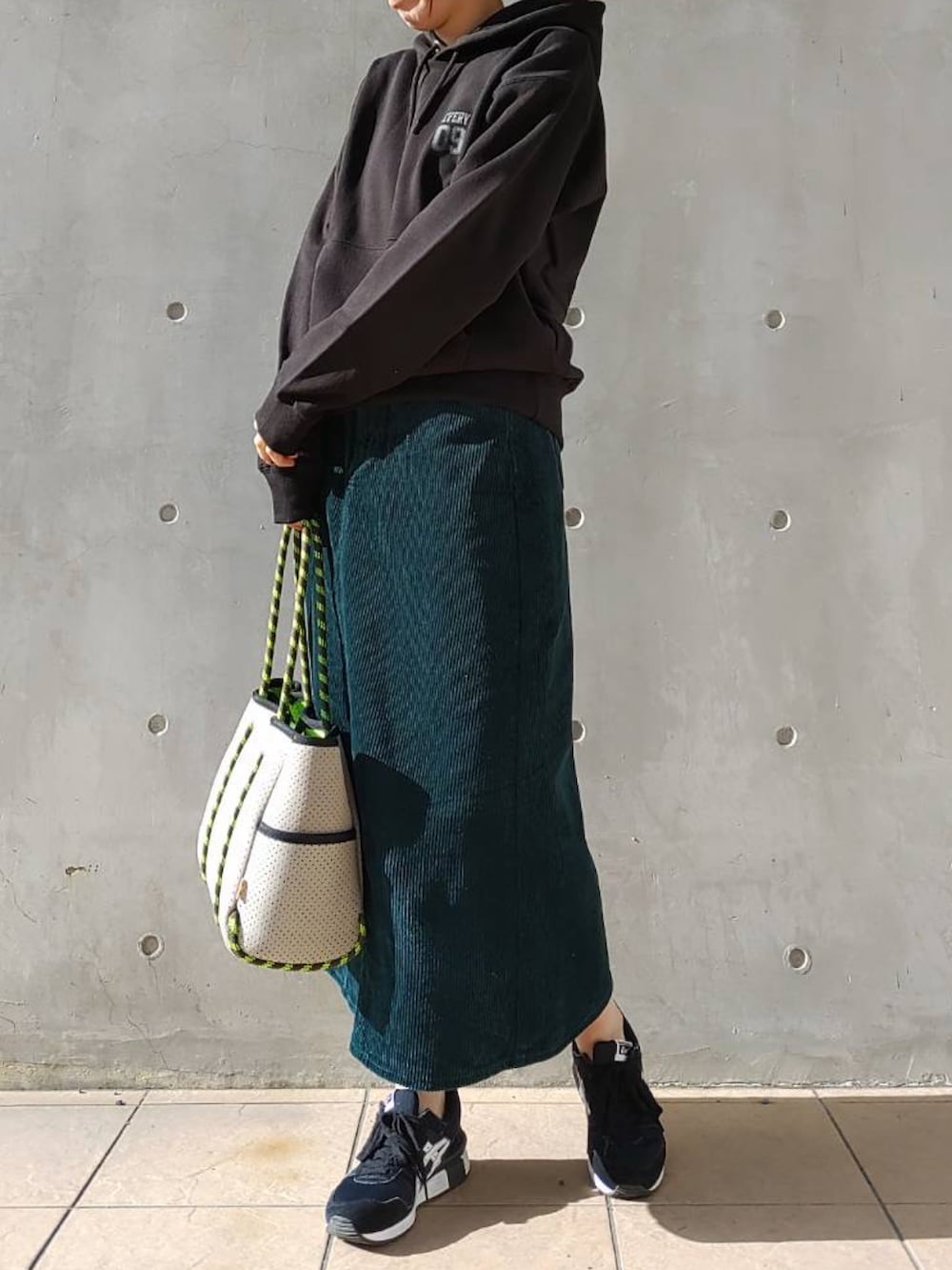 グリーン系のスカート、グレー系のトートバッグ、ブラック系のスニーカーを着用したレディースの冬コーディネートの2枚目の写真
