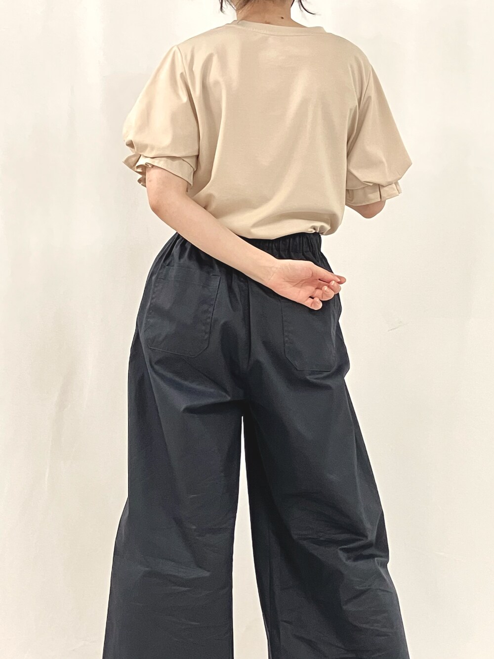 シルバー系のかごバッグ、ブラウン系のサンダル、ブルー系のスラックスを着用したレディースの夏コーディネートの5枚目の写真