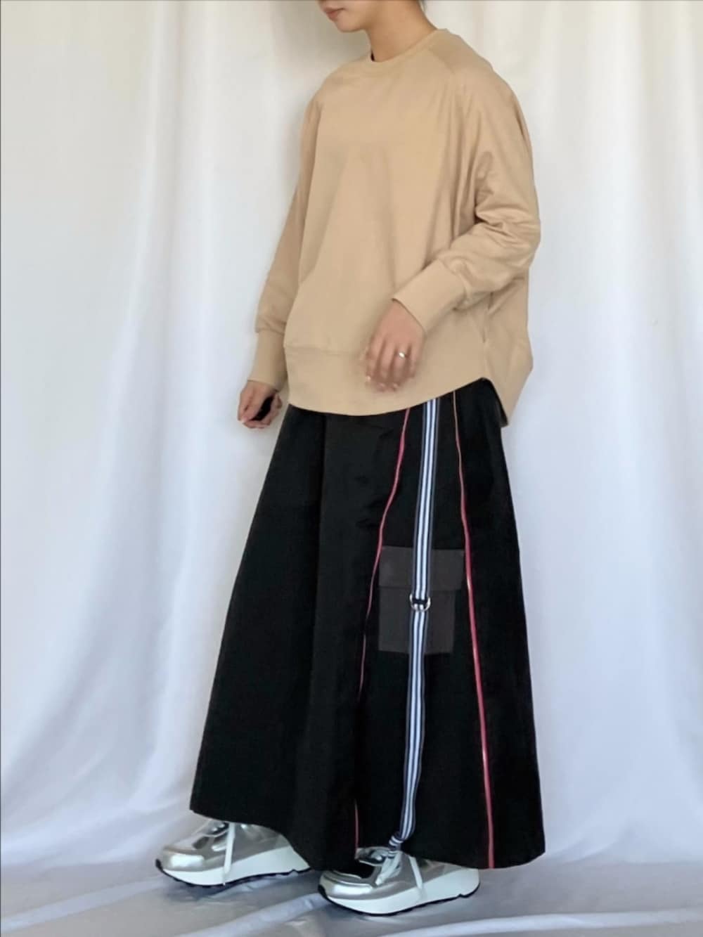 ベージュ系のスウェット、グレー系のスカート、シルバー系のスニーカーを着用したレディースの冬コーディネートの2枚目の写真