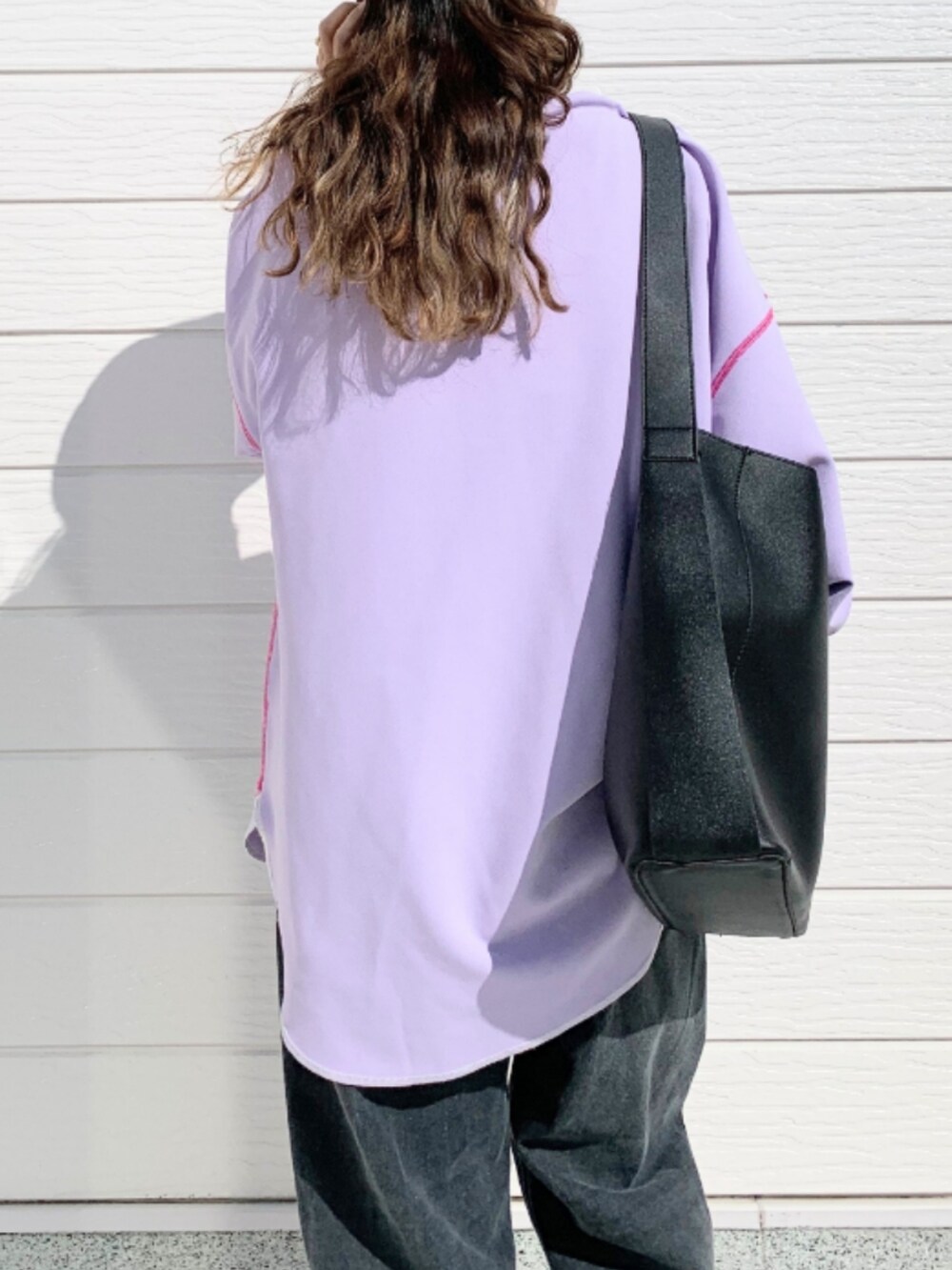 グレー系のデニムパンツ、ブラック系のトートバッグ、パープル系のTシャツ/カットソーを着用したレディースの春コーディネートの5枚目の写真