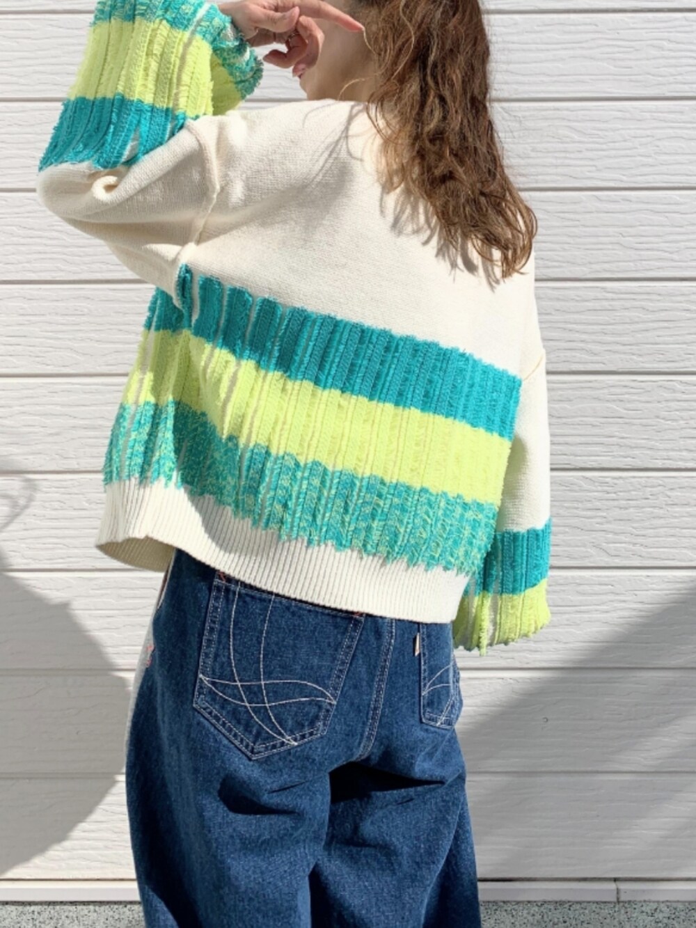 グレー系のデニムパンツ、ホワイト系のスニーカー、ホワイト系のTシャツ/カットソーを着用したレディースの冬コーディネートの3枚目の写真