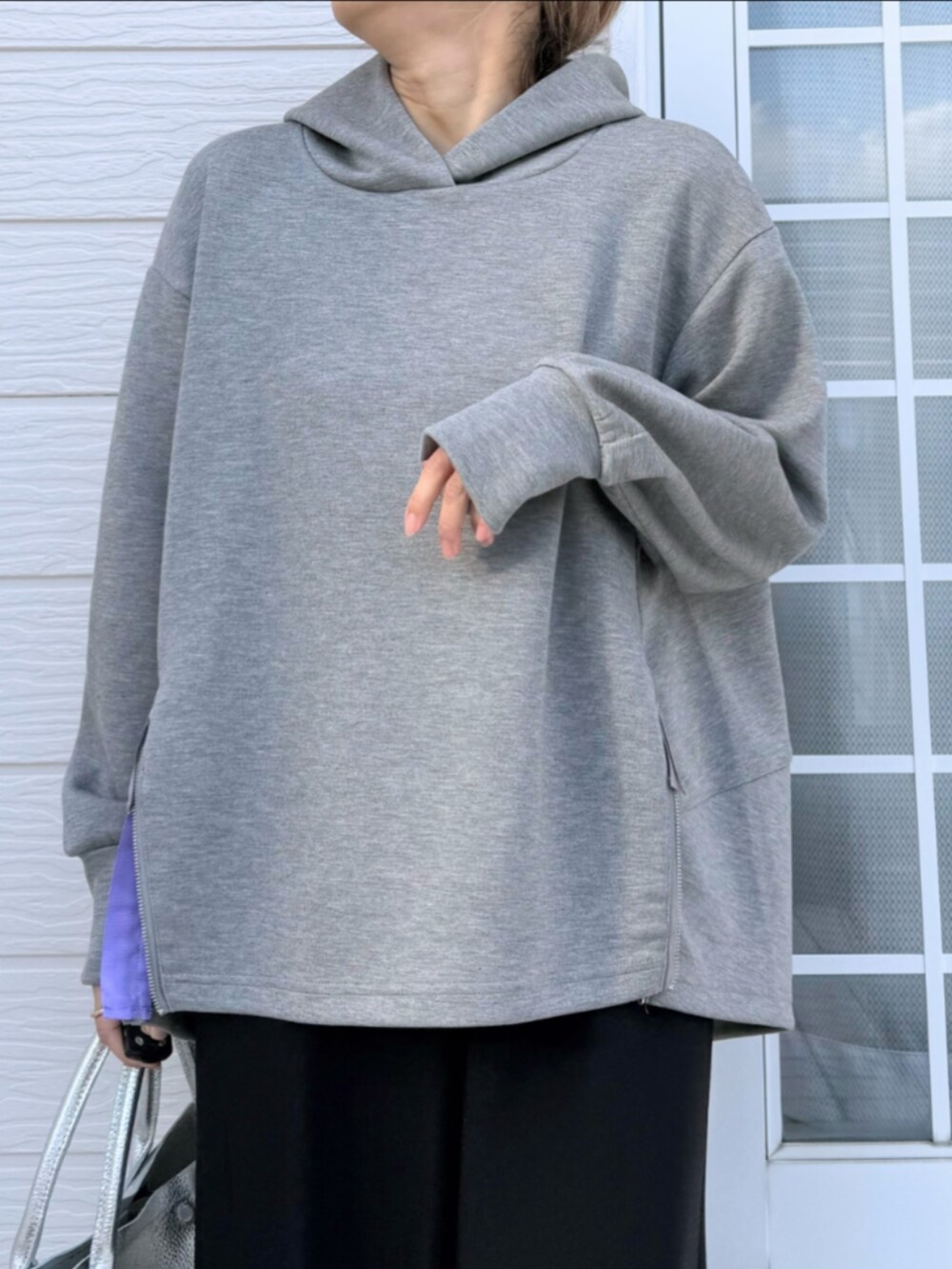 シルバー系のトートバッグ、ブラック系のその他パンツ、グレー系のパーカーを着用したレディースの冬コーディネートの4枚目の写真