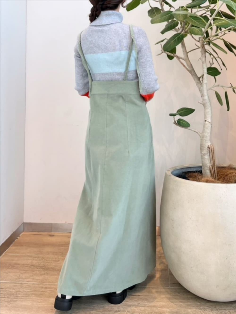 ホワイト系のブーツ、グリーン系のワンピース、グレー系のニット/セーターを着用したレディースの冬コーディネートの4枚目の写真