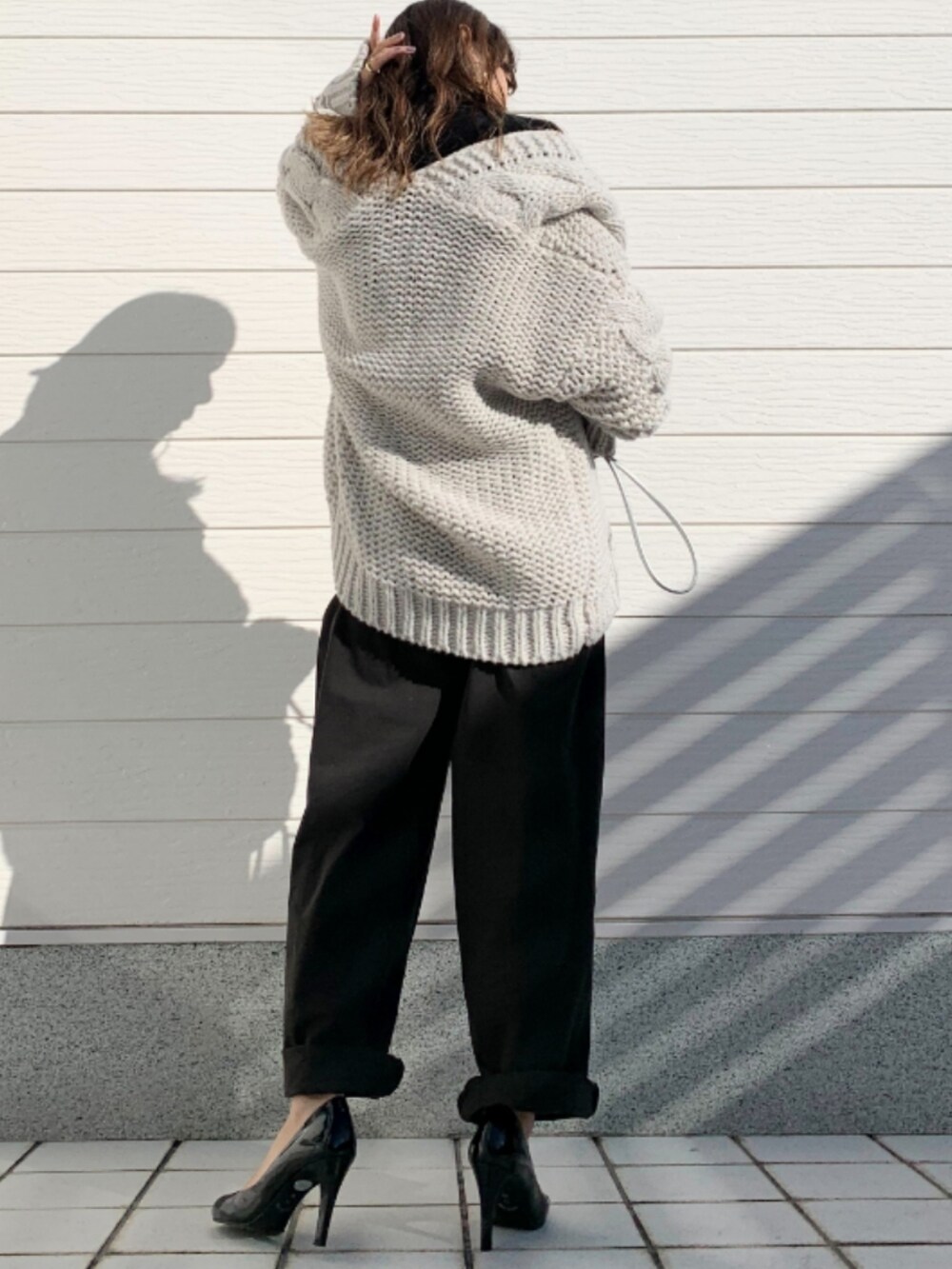 ブラック系のデニムパンツ、シルバー系のショルダーバッグ、グレー系のカーディガン/ボレロを着用したレディースの秋コーディネートの3枚目の写真