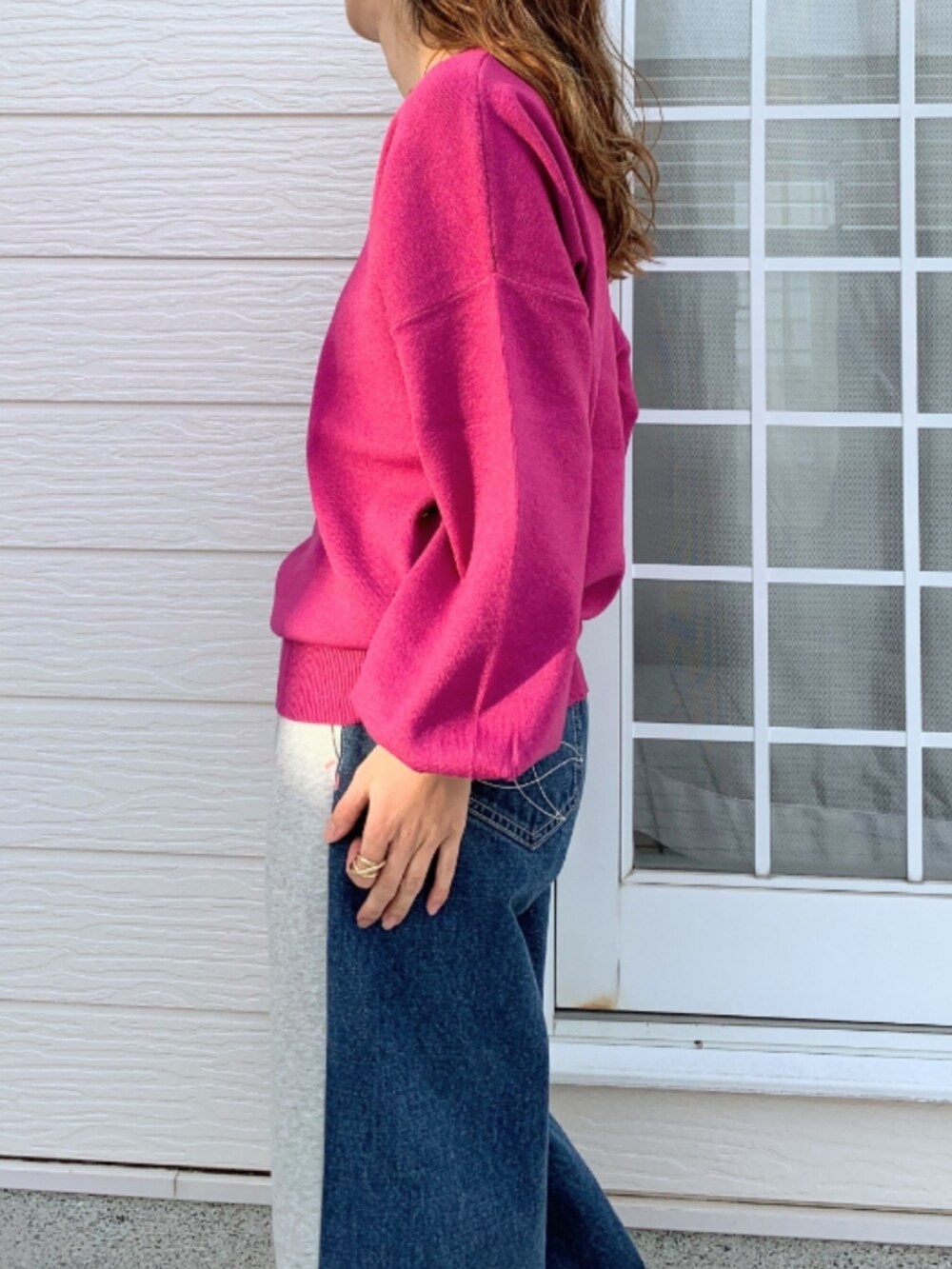 グレー系のデニムパンツ、シルバー系のスニーカー、ピンク系のニット/セーターを着用したレディースの冬コーディネートの4枚目の写真