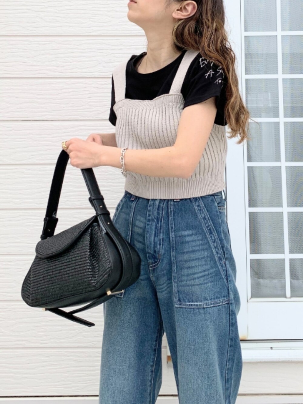 ブラック系のTシャツ/カットソー、ブラック系のショルダーバッグ、グレー系のベストを着用したレディースの春コーディネートの5枚目の写真