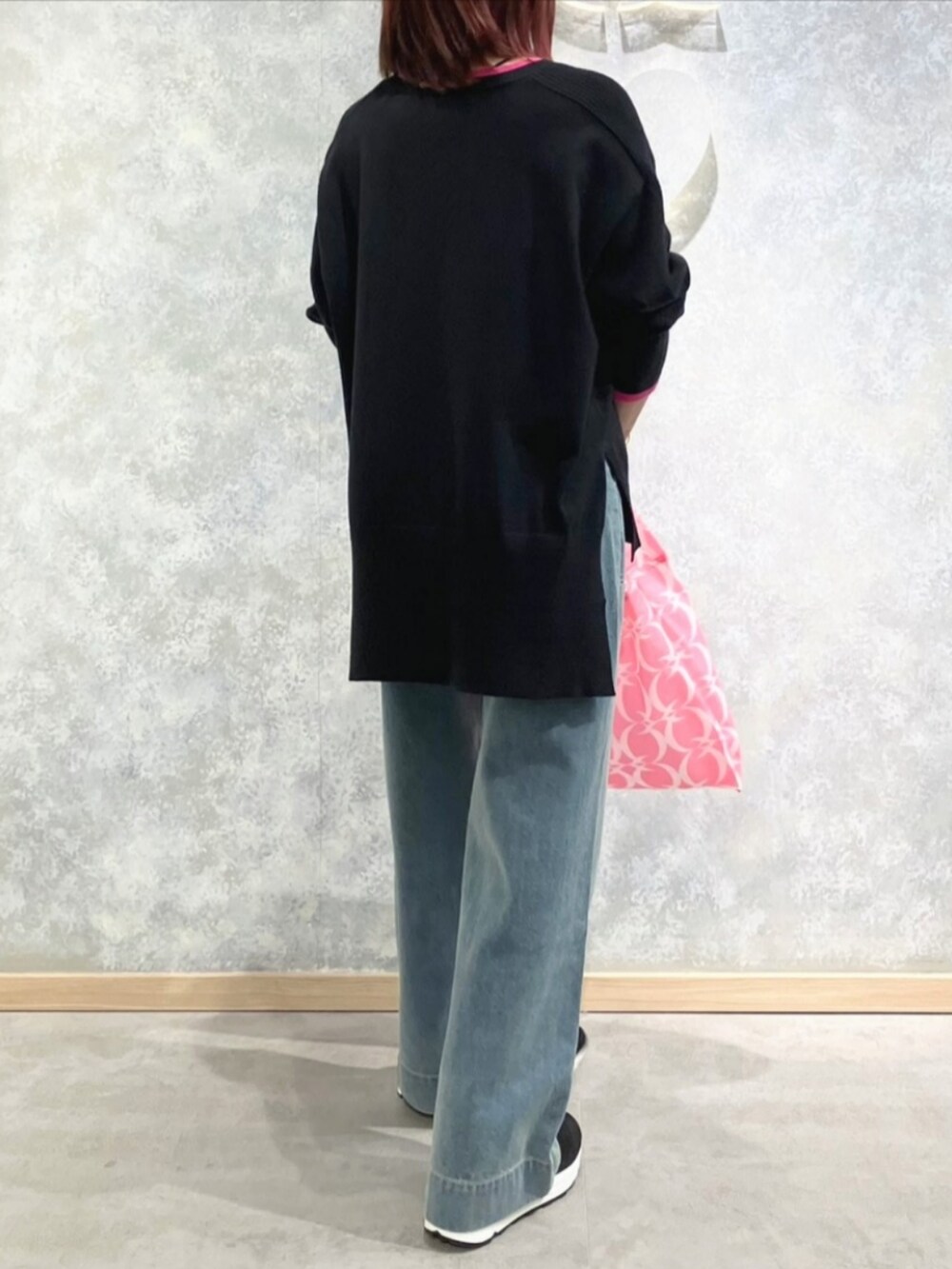 ブルー系のデニムパンツ、グレー系のブーツ、ピンク系のエコバッグ/サブバッグを着用したレディースの秋コーディネートの3枚目の写真