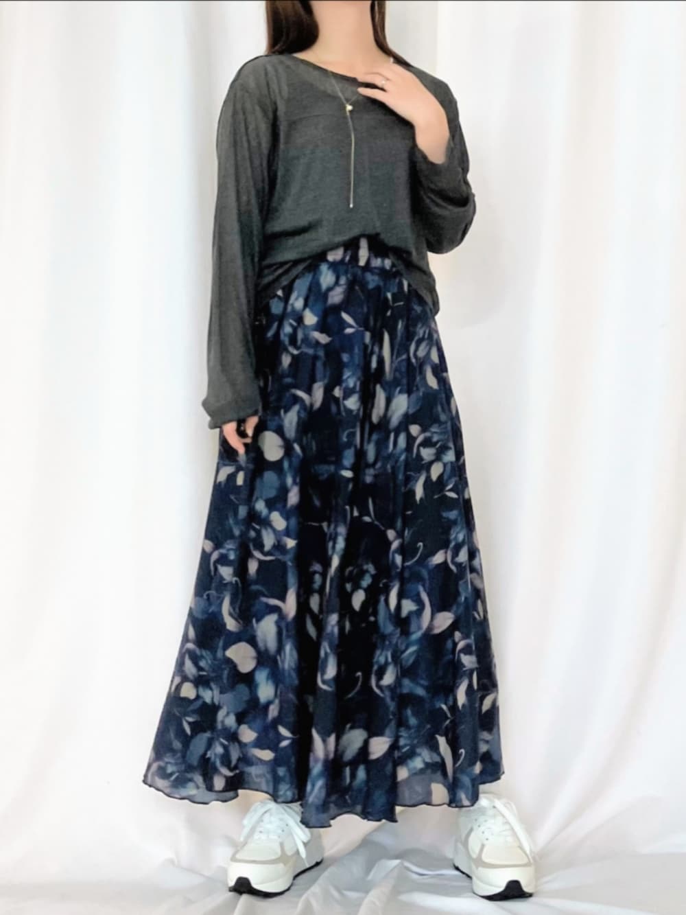 ホワイト系のスニーカー、ブルー系のスカート、グレー系のTシャツ/カットソーを着用したレディースの冬コーディネートの2枚目の写真