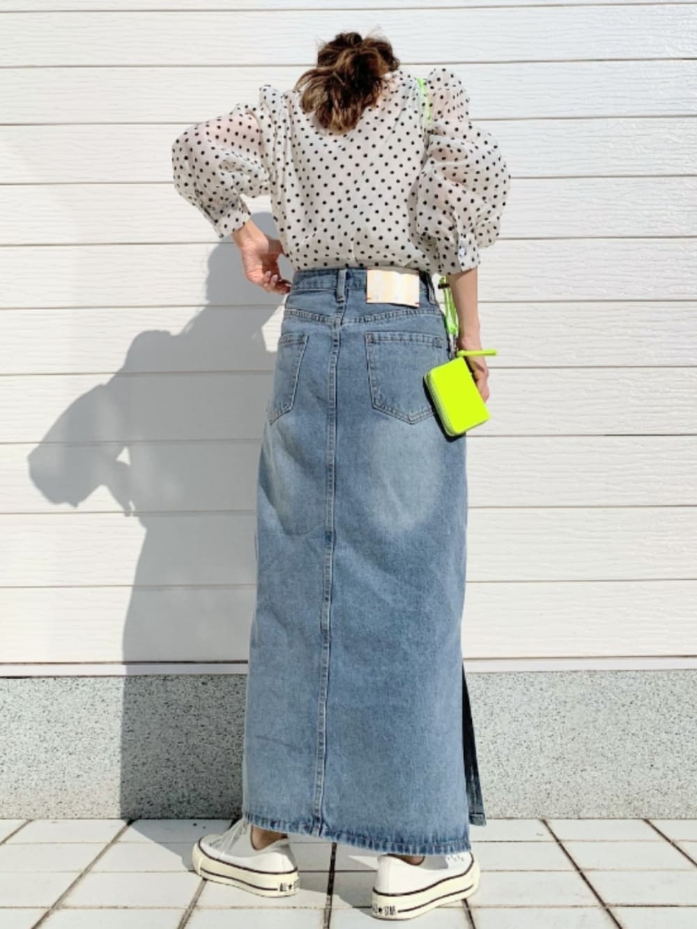 ブルー系のデニムスカート、ホワイト系のスニーカー、ベージュ系のシャツ/ブラウスを着用したレディースの春コーディネートの3枚目の写真