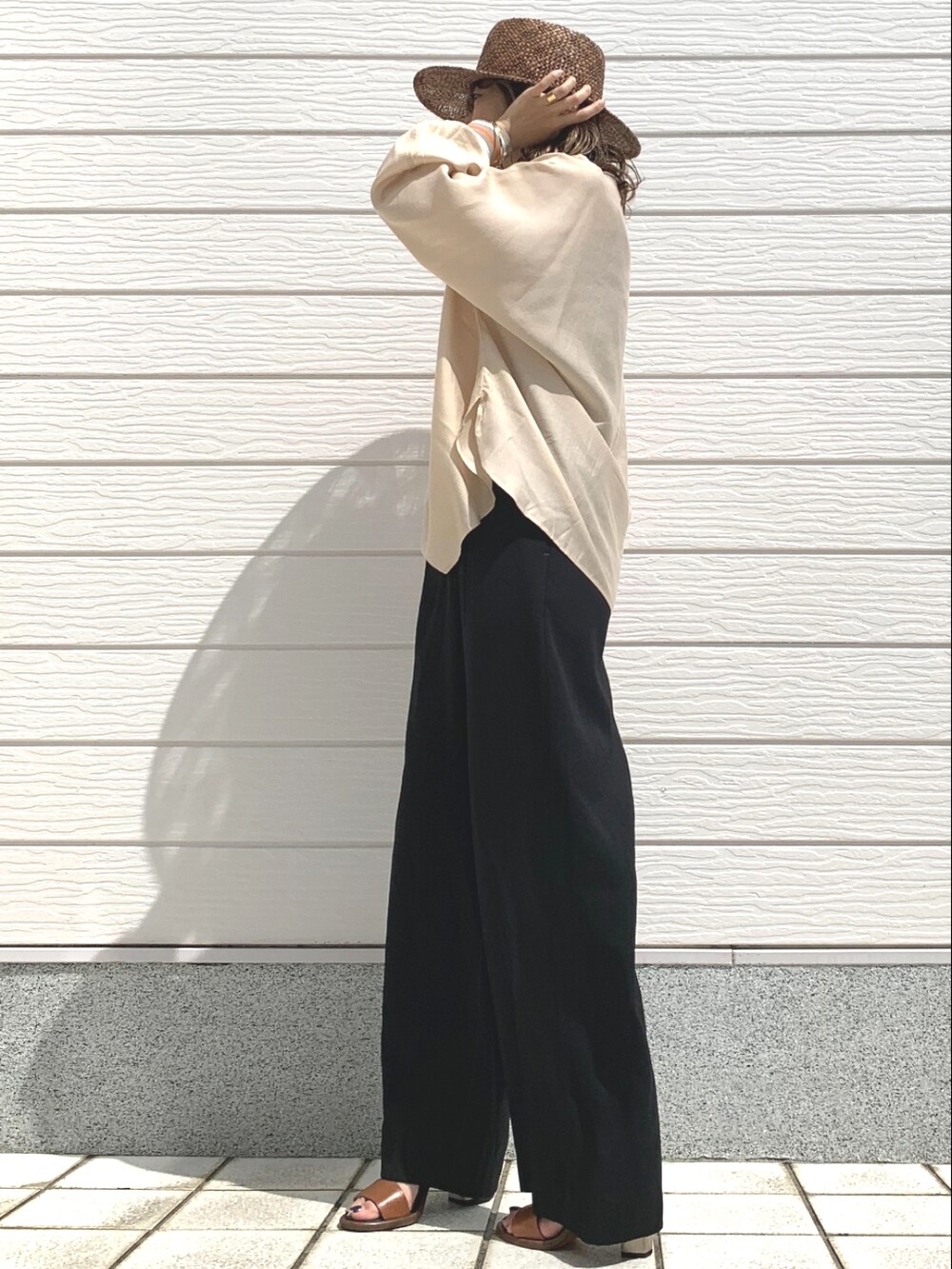 ブラック系のその他パンツ、ベージュ系のシャツ/ブラウス、ブラウン系のサンダルを着用したレディースの春コーディネートの2枚目の写真