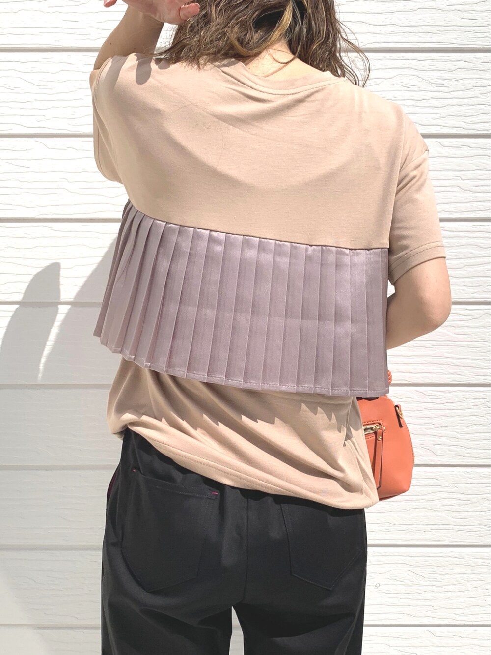 ブラック系のその他パンツ、ベージュ系のTシャツ/カットソー、オレンジ系のハンドバッグを着用したレディースの春コーディネートの4枚目の写真