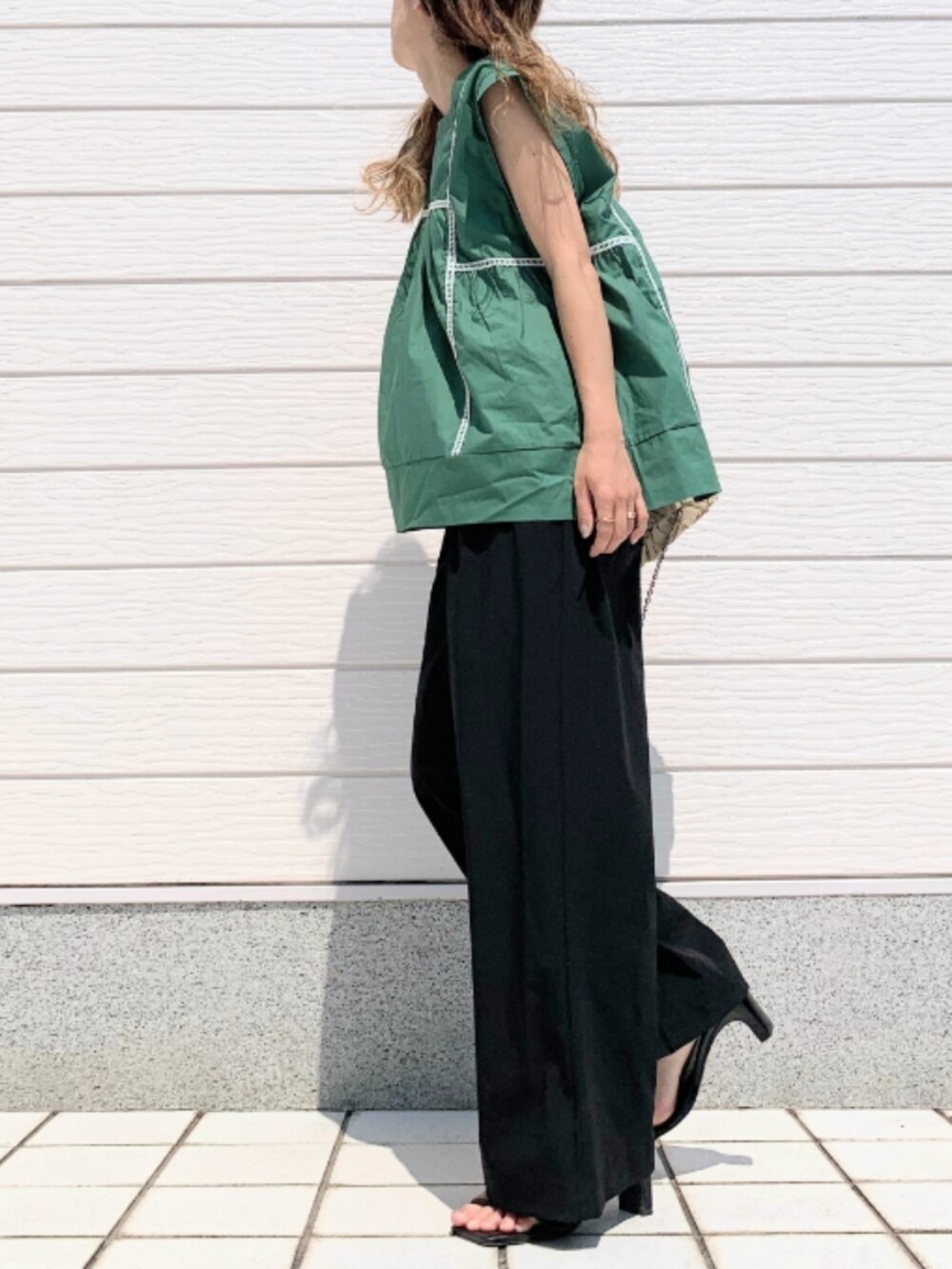 ブラック系のその他パンツ、グリーン系のシャツ/ブラウス、ベージュ系のクラッチバッグを着用したレディースの夏コーディネートの2枚目の写真