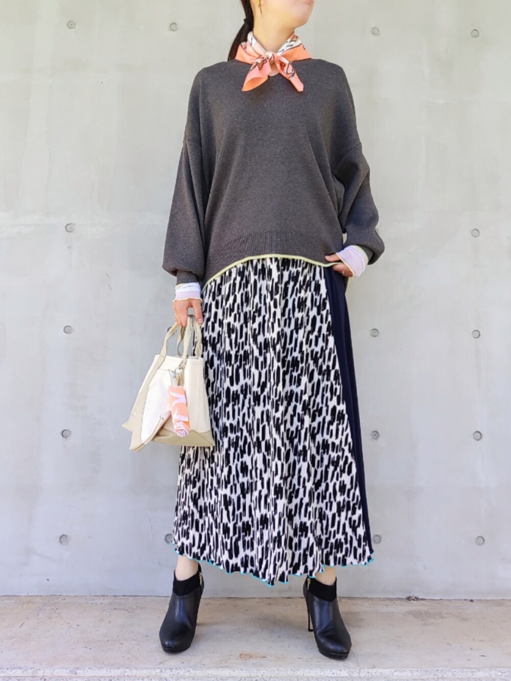 ベージュ系のトートバッグ、オレンジ系のエコバッグ/サブバッグ、ブルー系のスカートを着用したレディースの秋コーディネートの2枚目の写真