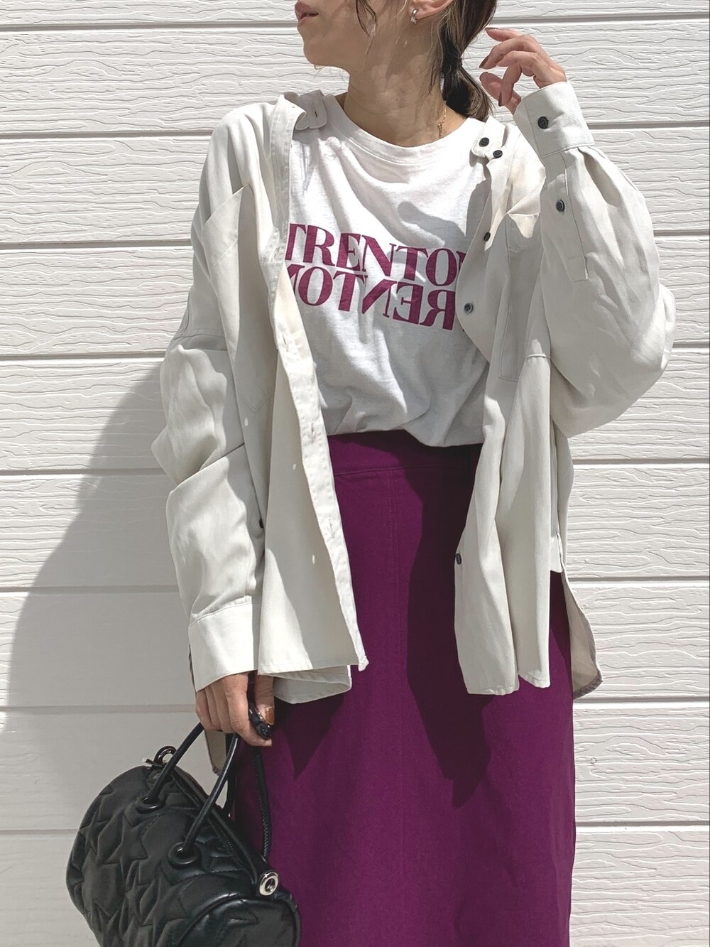 ブラック系のサンダル、ブラック系のドラムバッグ、ホワイト系のTシャツ/カットソーを着用したレディースの秋コーディネートの2枚目の写真