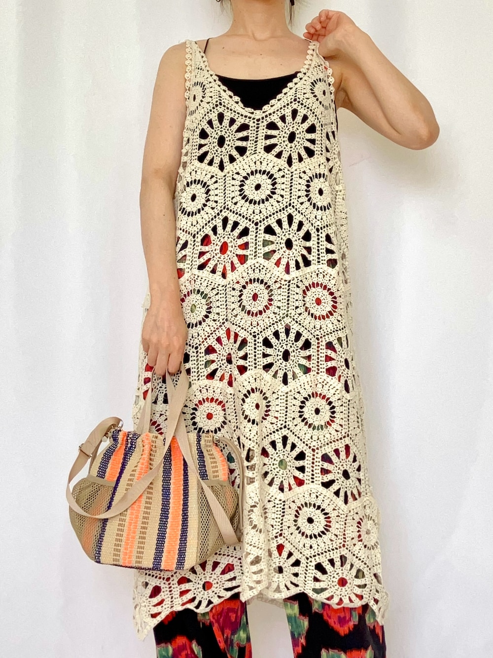 ベージュ系のトートバッグ、ホワイト系のワンピース、ブラック系のキャミソールを着用したレディースの夏コーディネートの4枚目の写真