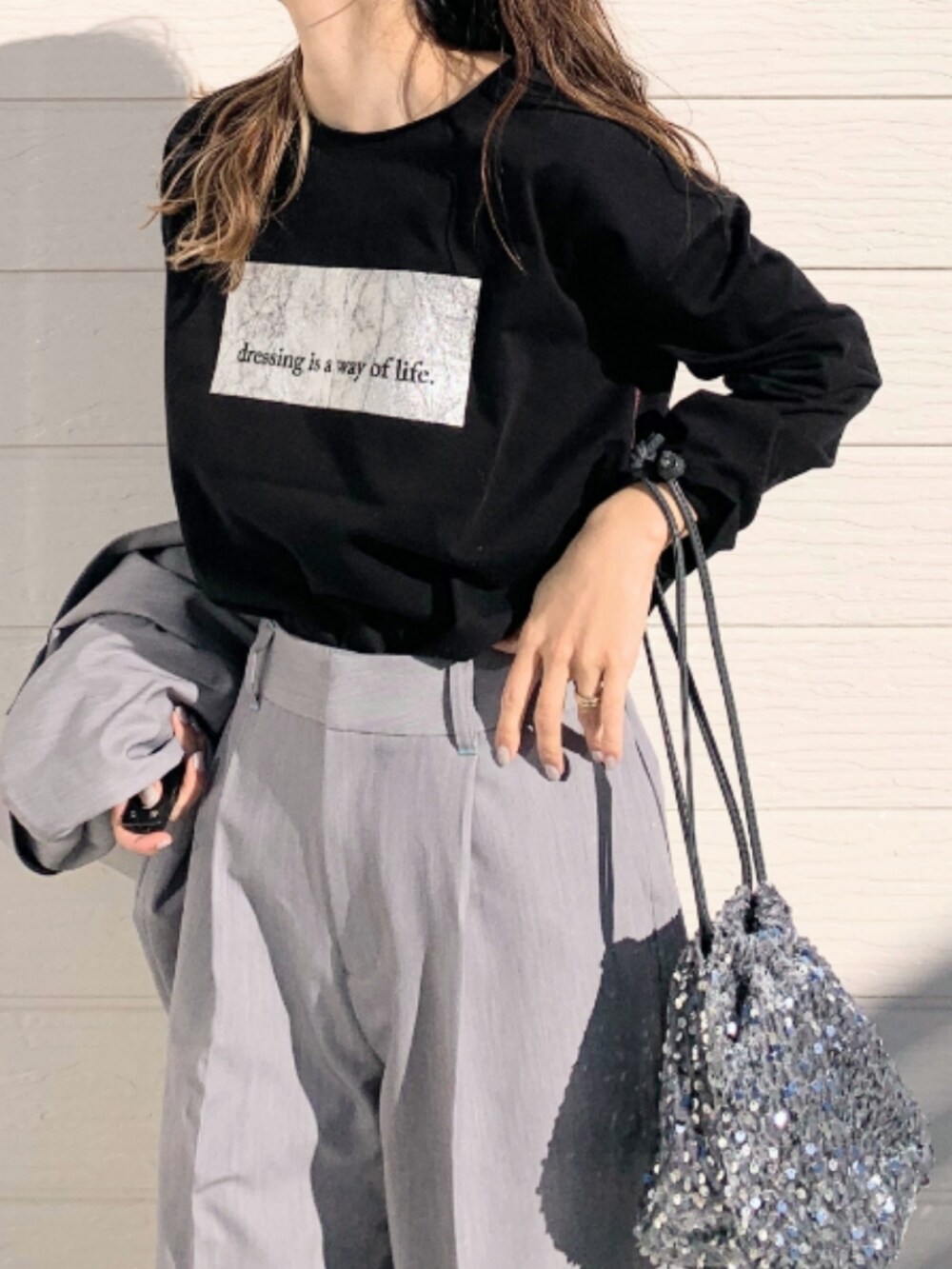 シルバー系のスニーカー、グレー系のスラックス、グレー系のテーラードジャケットを着用したレディースの冬コーディネートの4枚目の写真